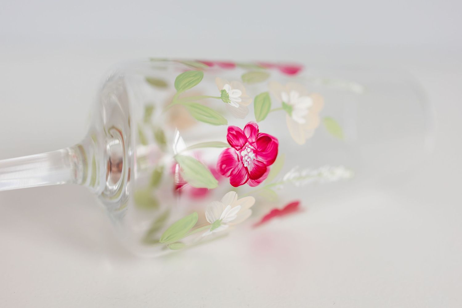 A clear resin ring featuring delicate pink flowers and green leaves embedded within the transparent material.