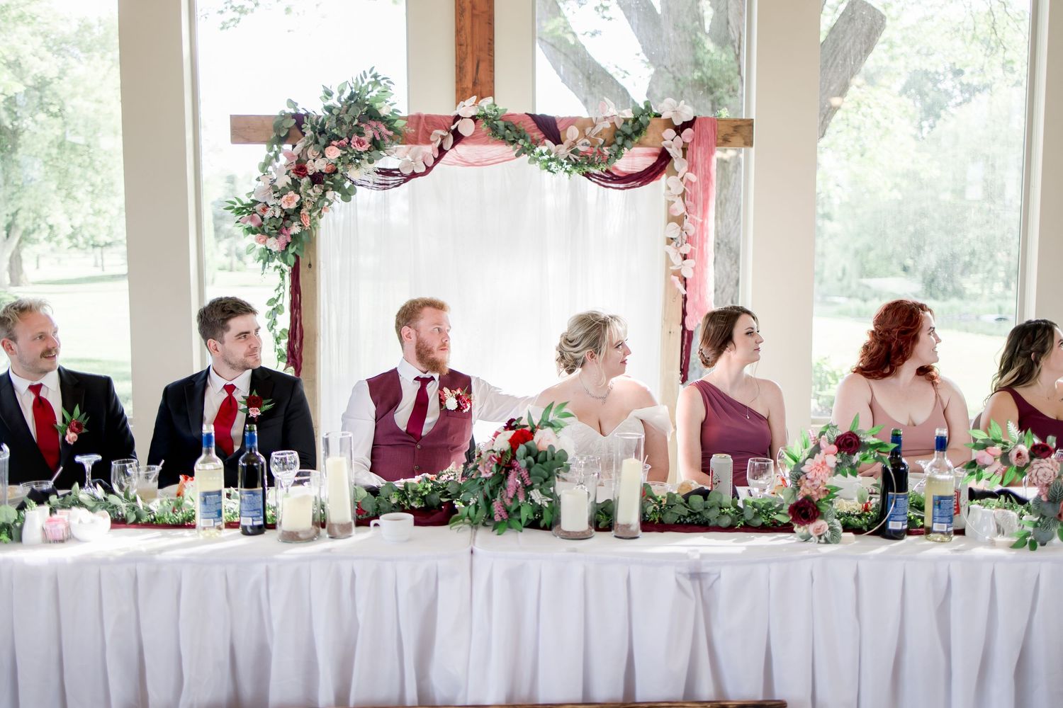 Panoramic view of wedding reception venue with decorated head table and guest seating.
