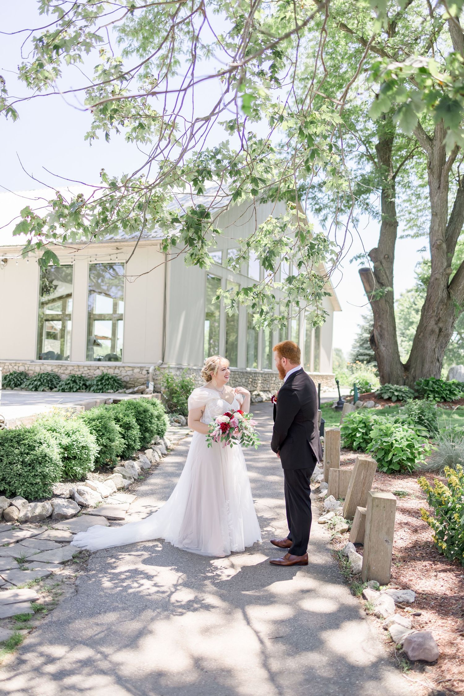 Outdoor wedding venue with stone architecture and tree-lined pathways.