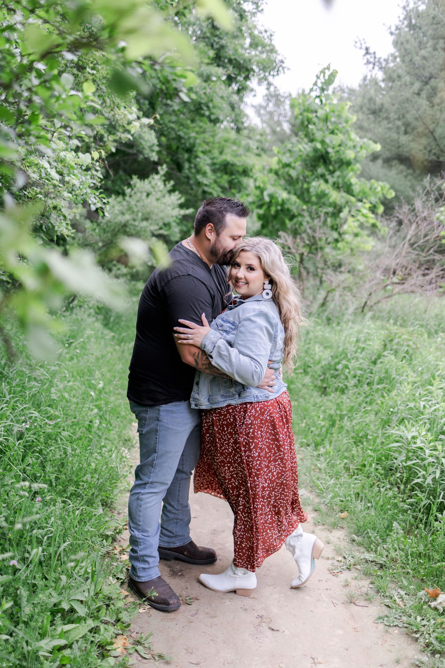 Romantic couple sharing tender moments on a secluded nature trail.