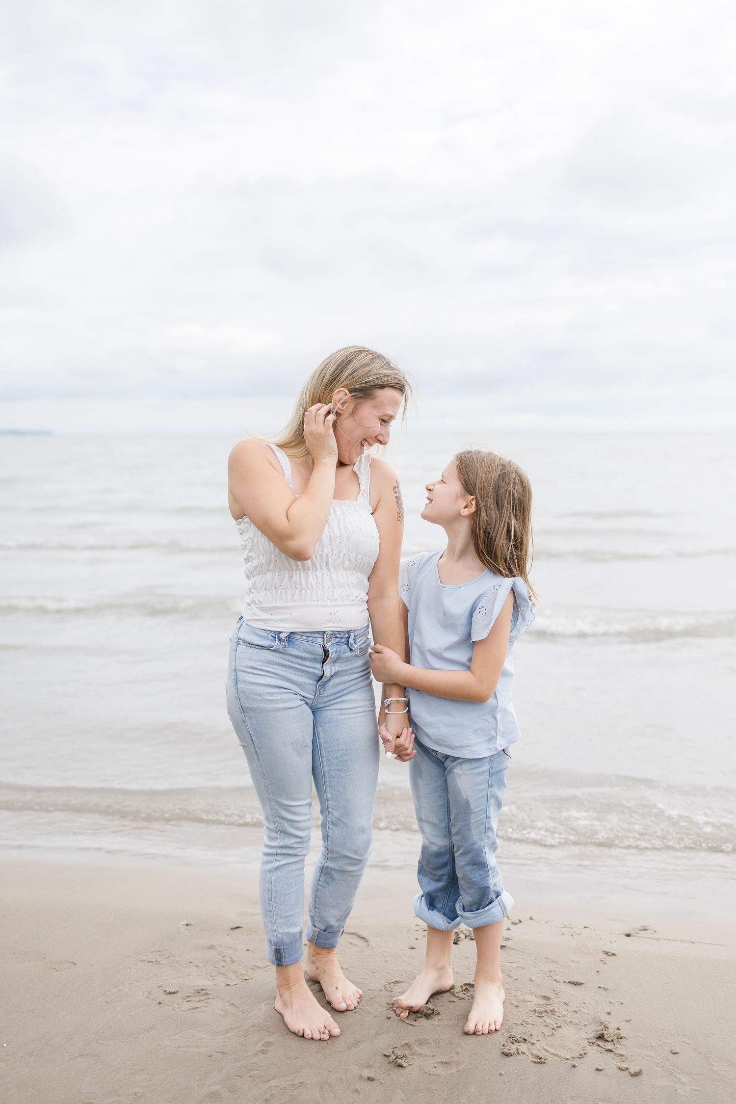 Mother and child sharing a tender moment on the beach.