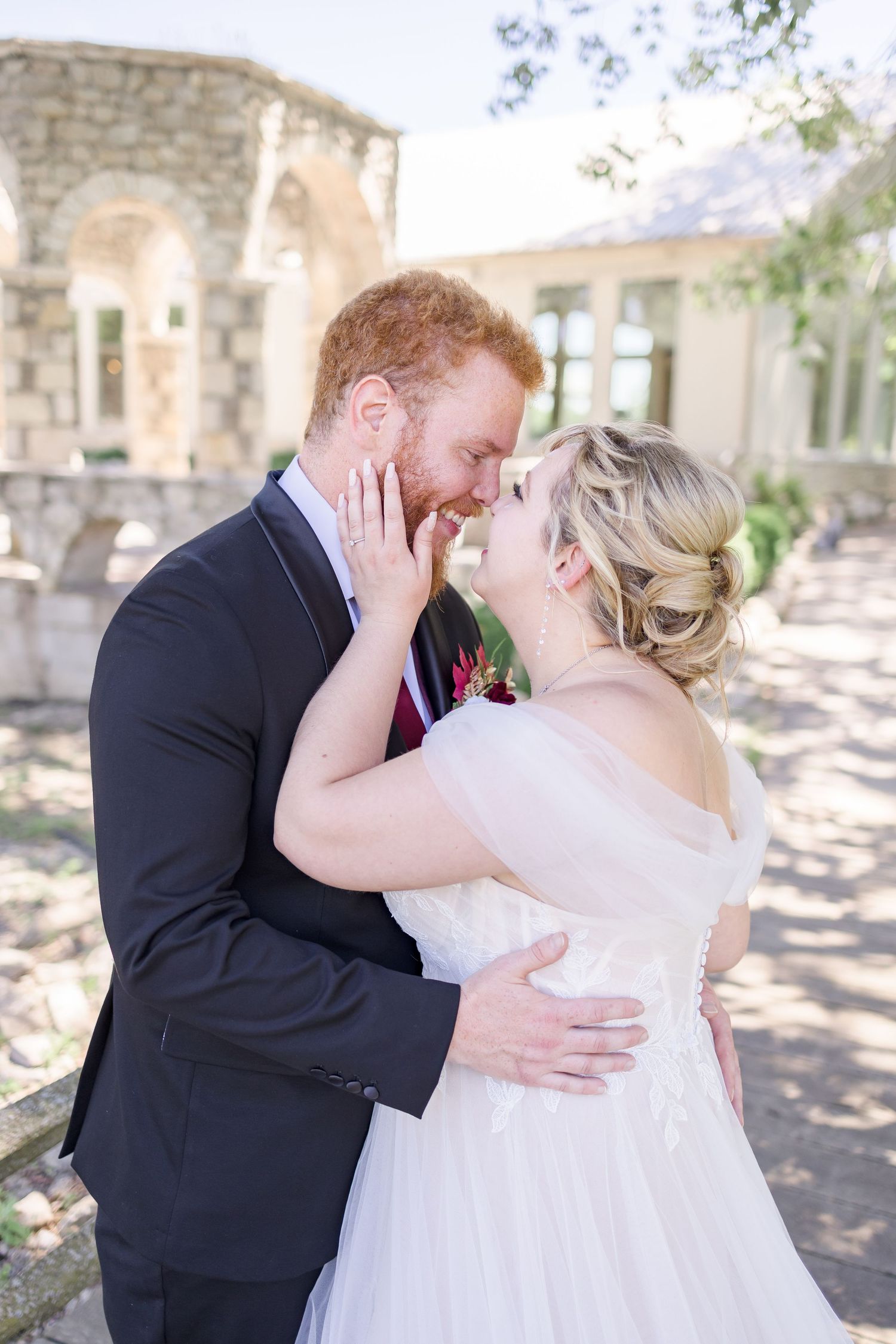 Wedding couple embracing during first look photos in garden setting.