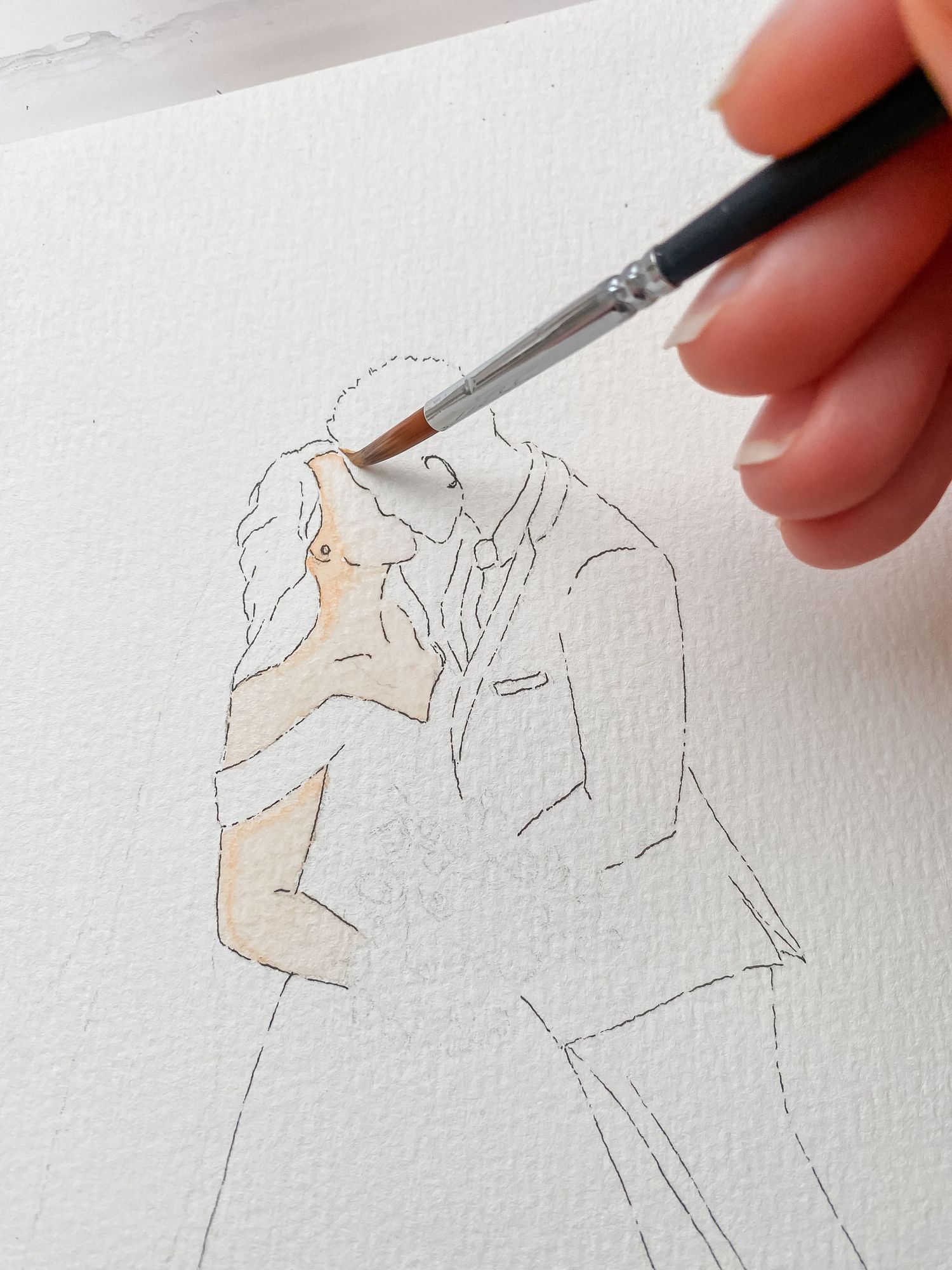 Artist's hand sketching a delicate pencil portrait and adding subtle watercolor details on white paper.