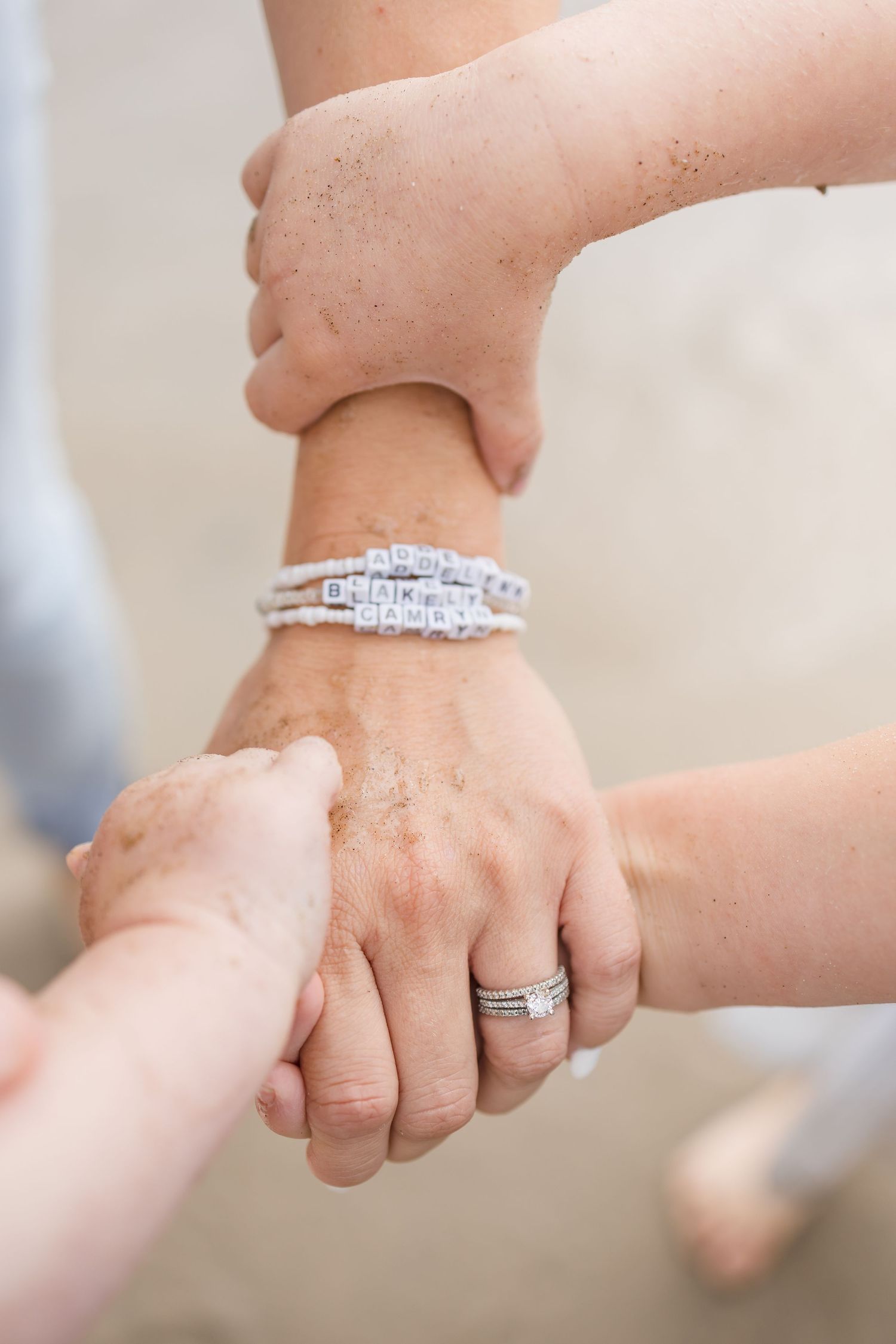 Close-up detail shots of hands wearing wedding rings and bracelets.