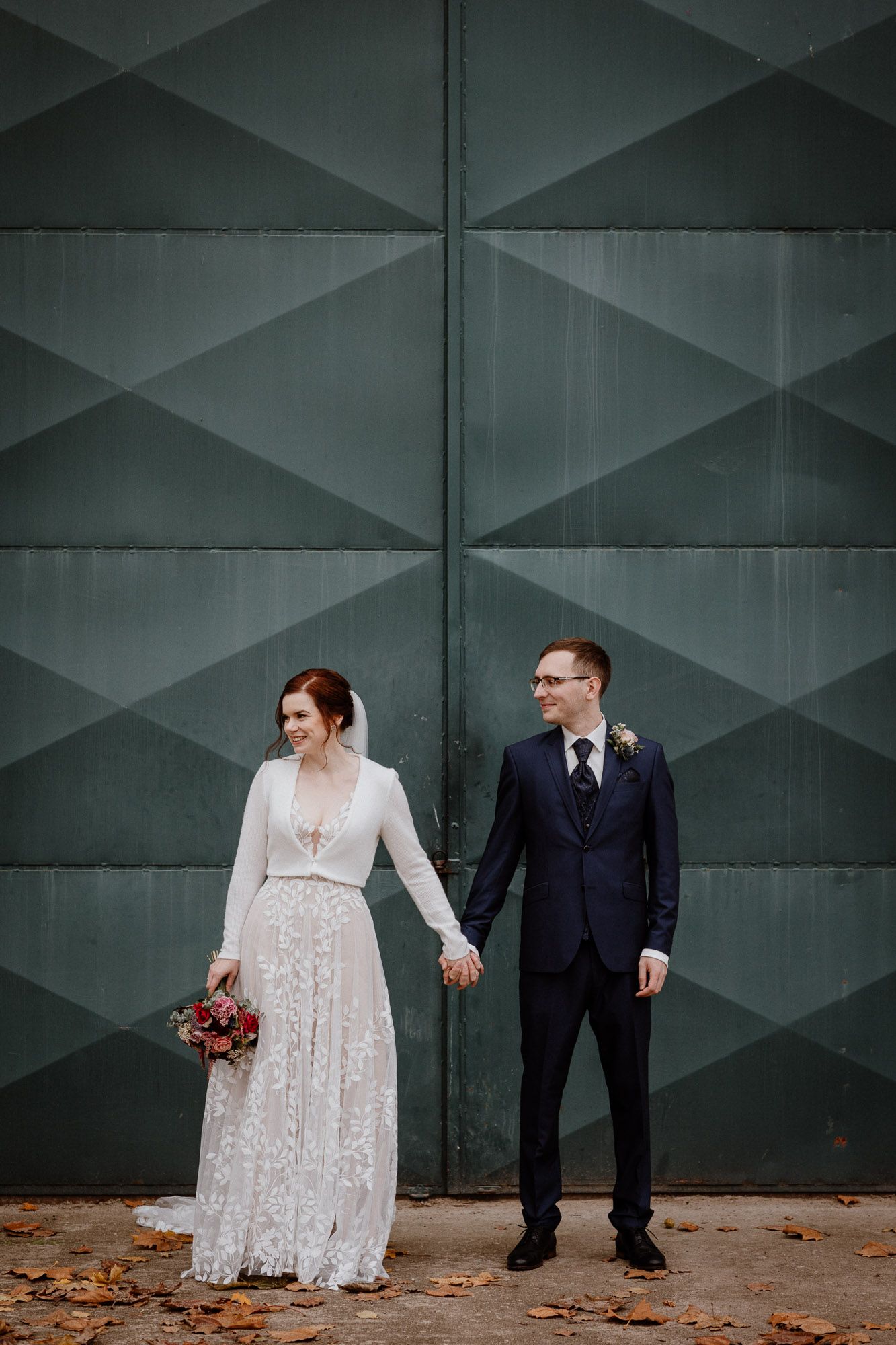 Modern wedding portrait against geometric green wall.