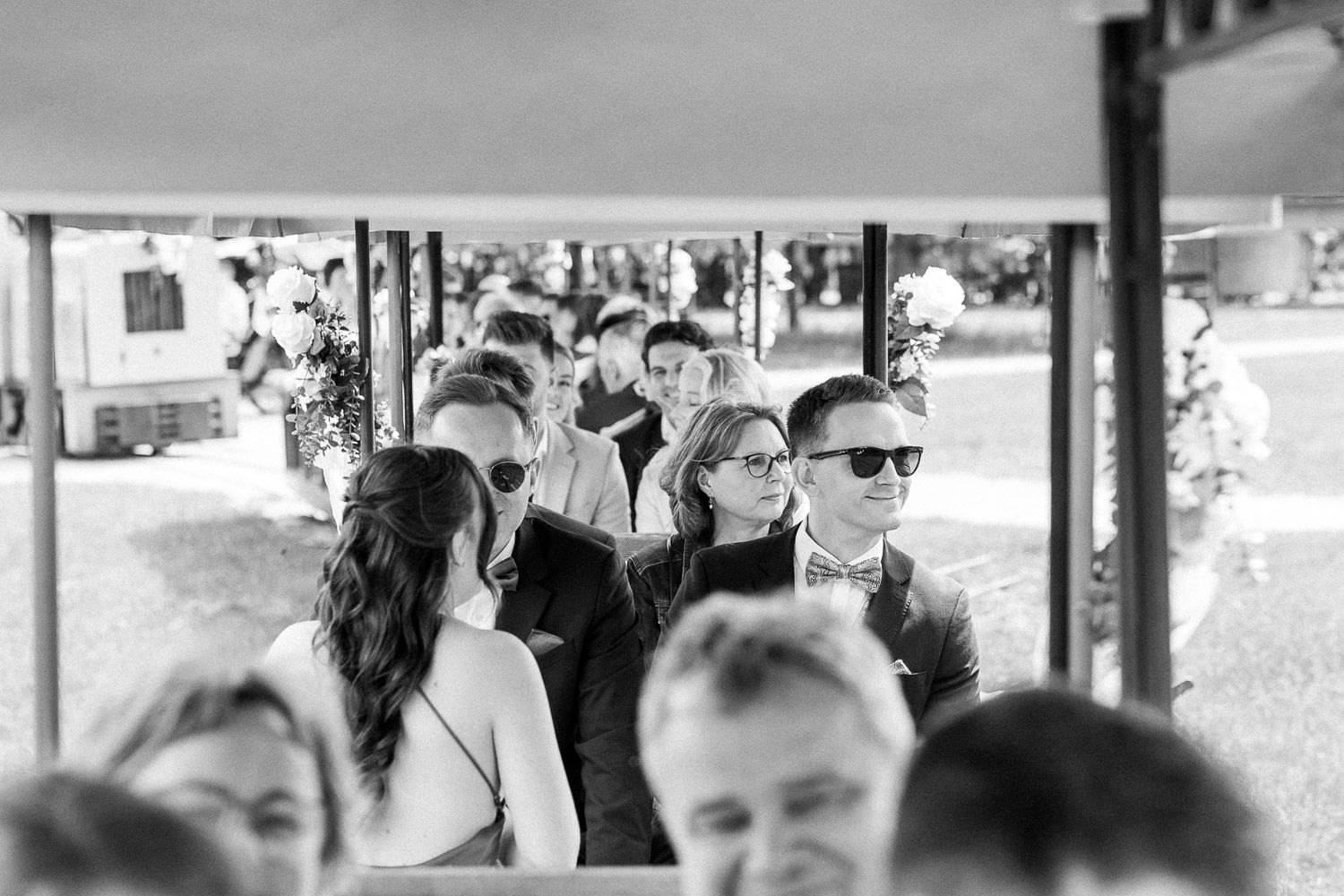 Wedding ceremony venue setup with rows of white chairs under a covered outdoor space.