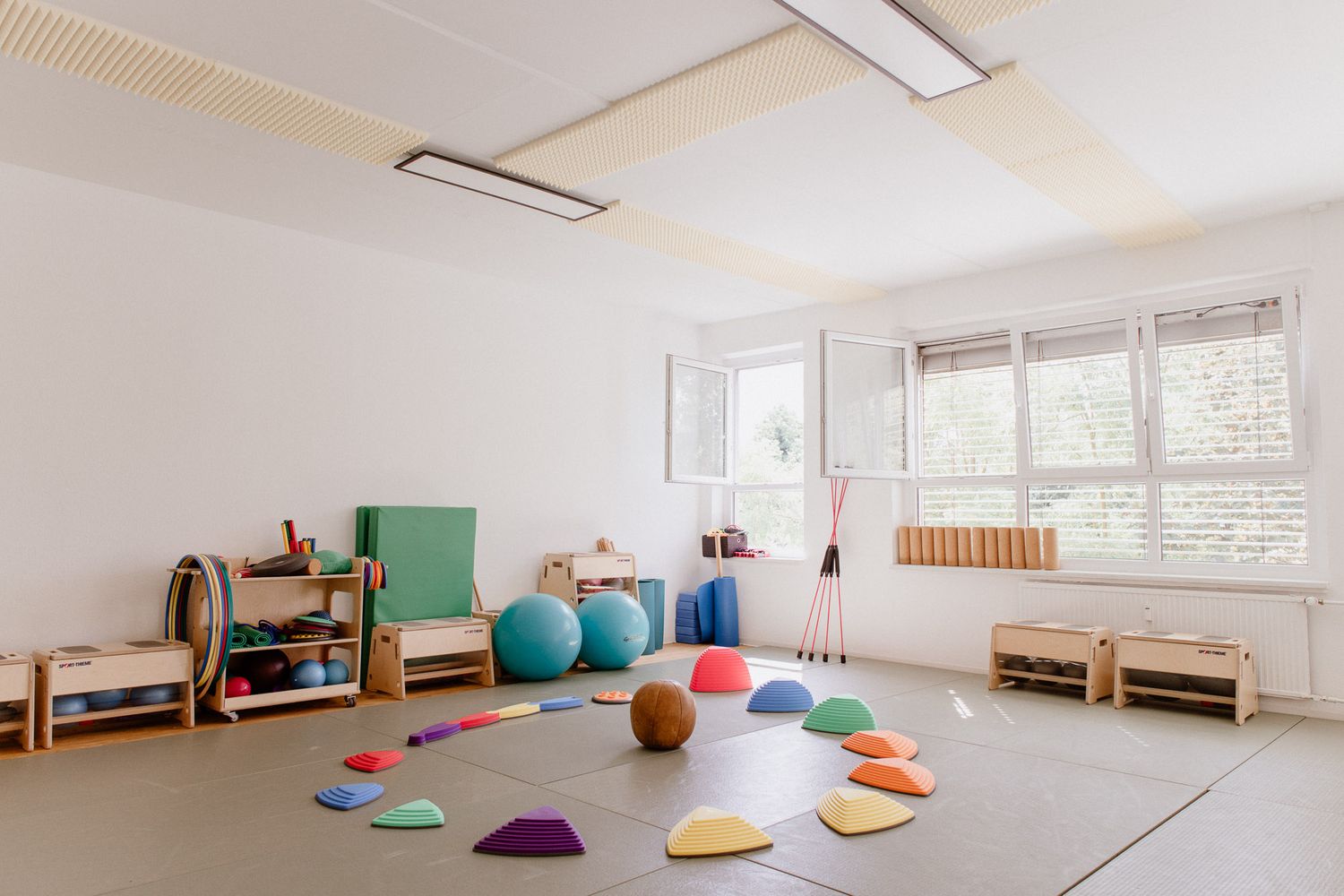 Spacious yoga studio with natural light, colorful cushions, and minimalist decor.
