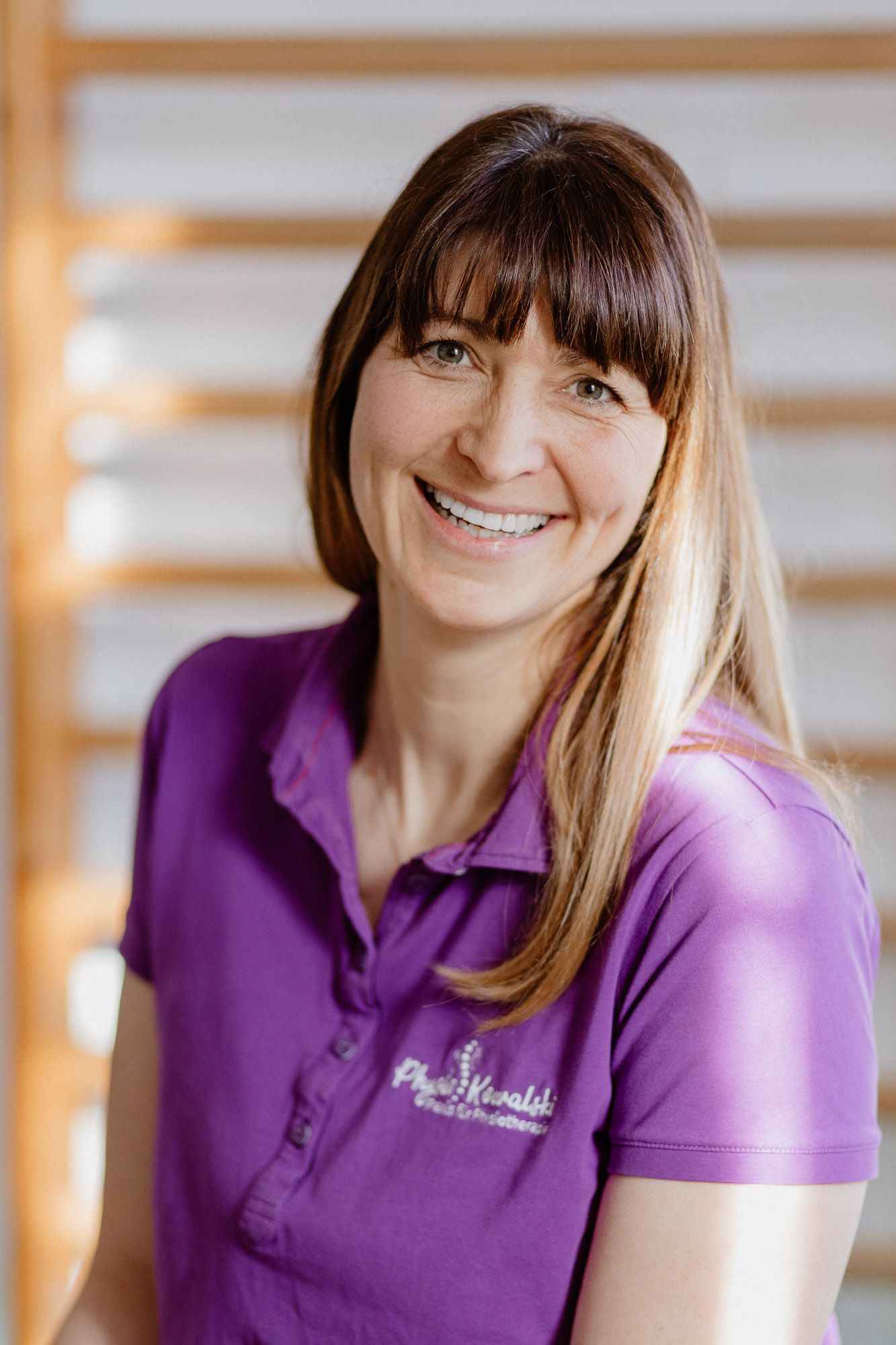 Healthcare professional in purple polo shirt at workplace.