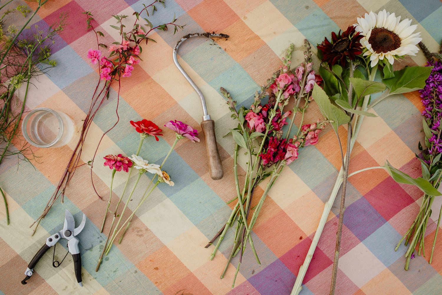 Colorful floral arrangement with pink flowers and greenery laid out in an artistic pattern.