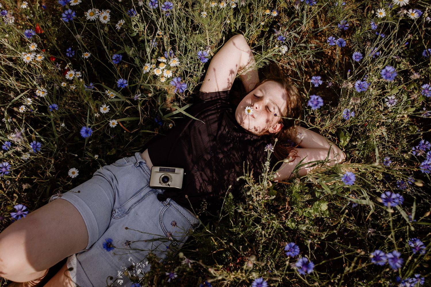 Candid shot of someone lying in a field of wildflowers during summer.