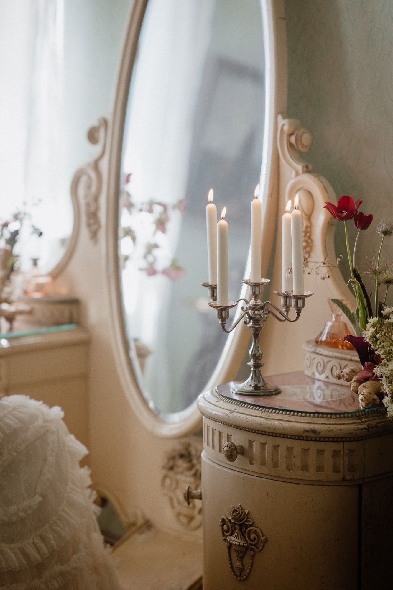 Vintage-style vanity with ornate mirror, candelabra and romantic decor.