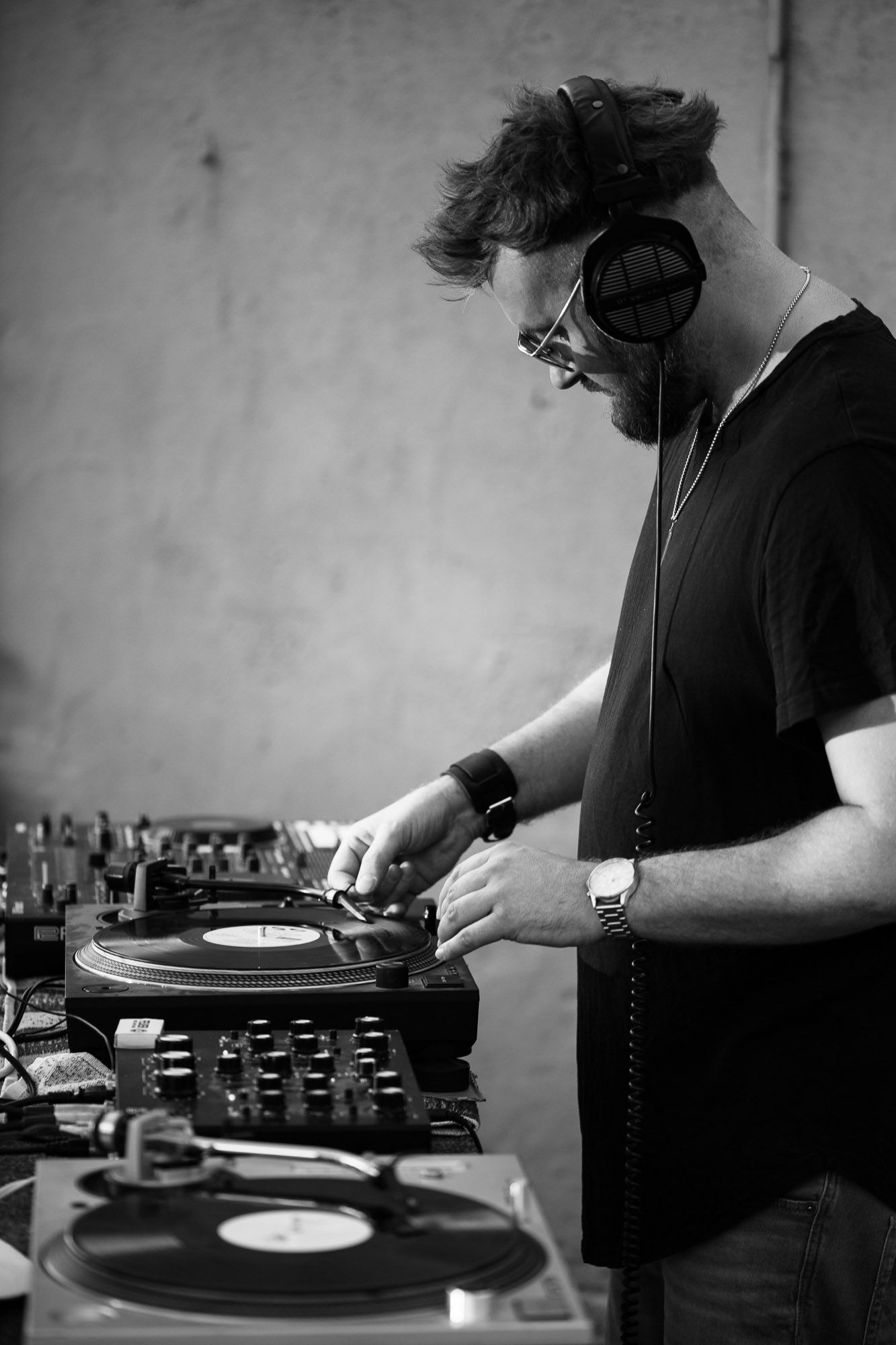 DJ working turntables in black and white photography sequence.