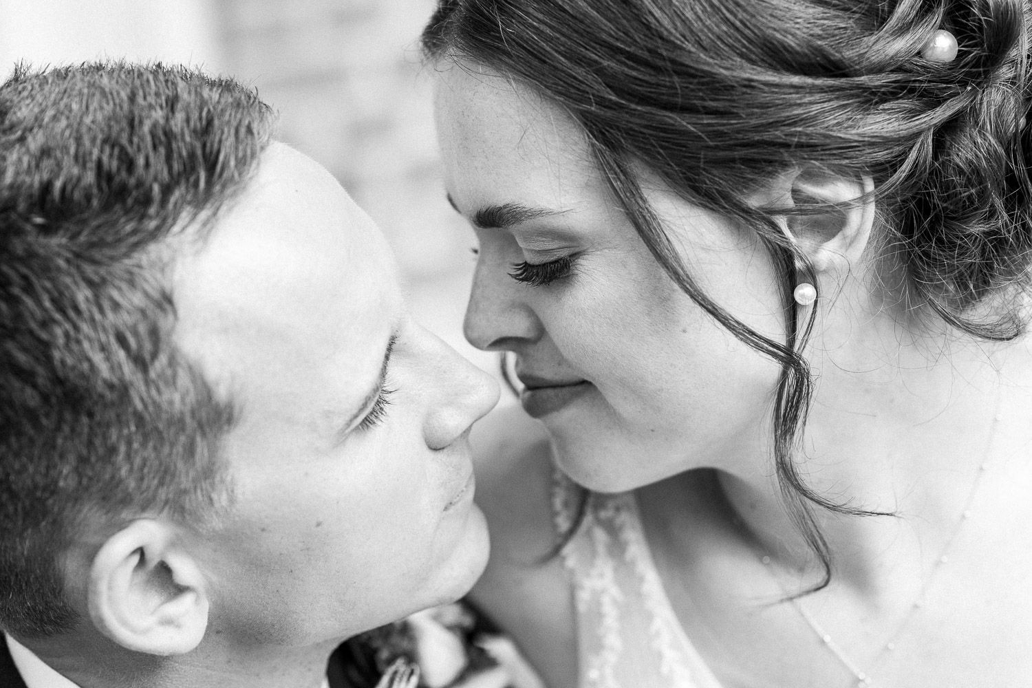 Black and white close-up of tender moment between newlyweds.