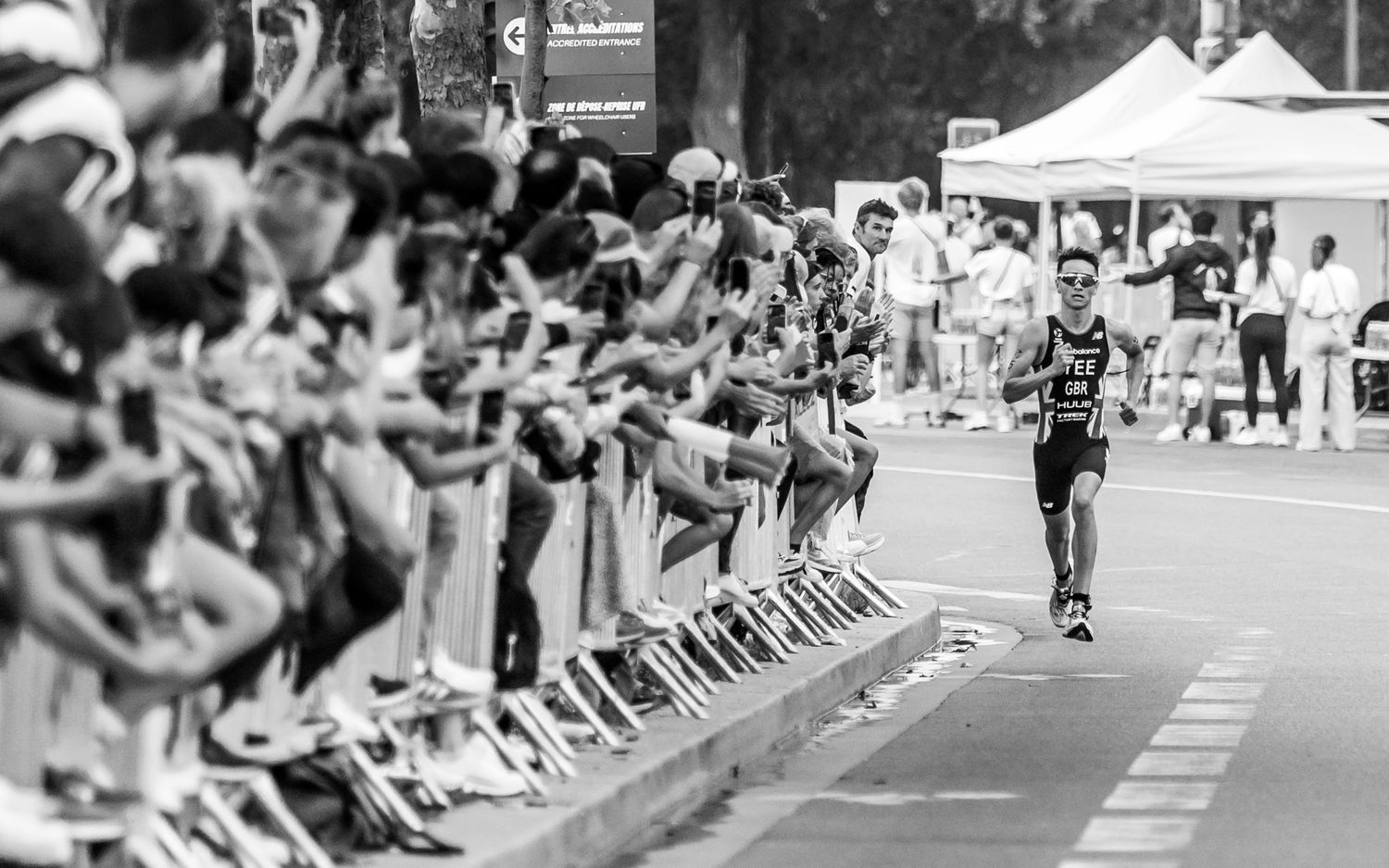 alex yee racing along course with spectators cheering from sidelines.