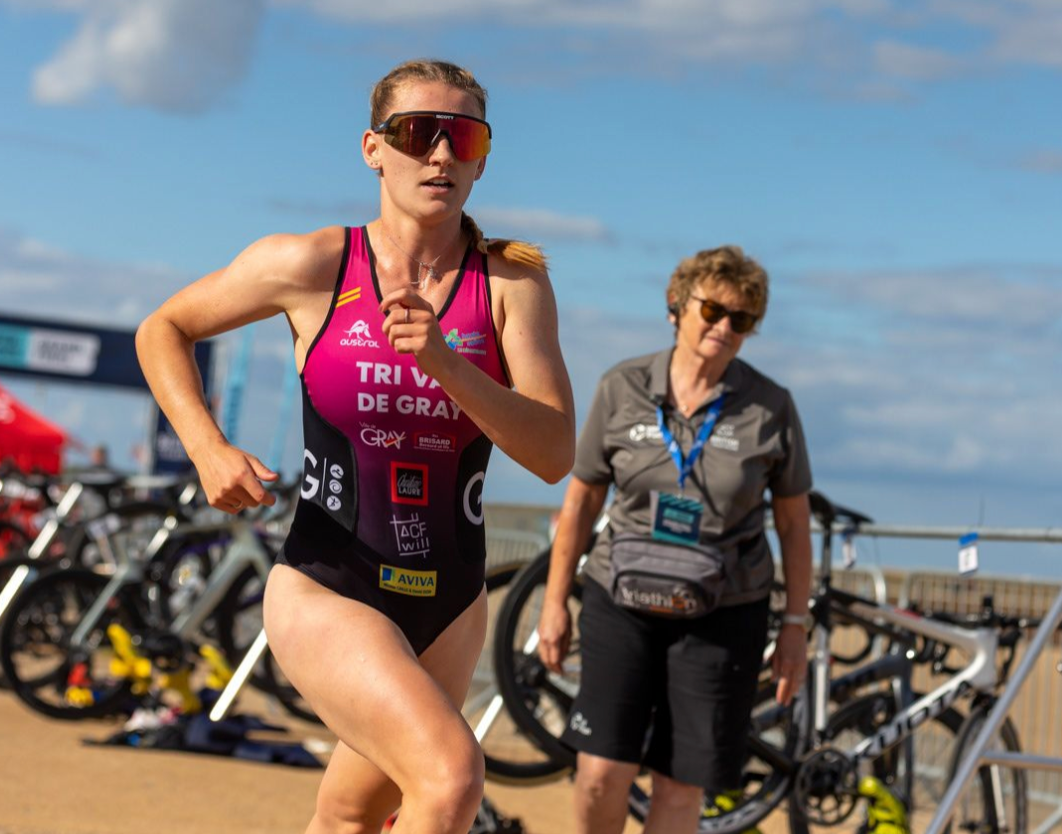 Athletes preparing their bikes at transition area during triathlon competition.