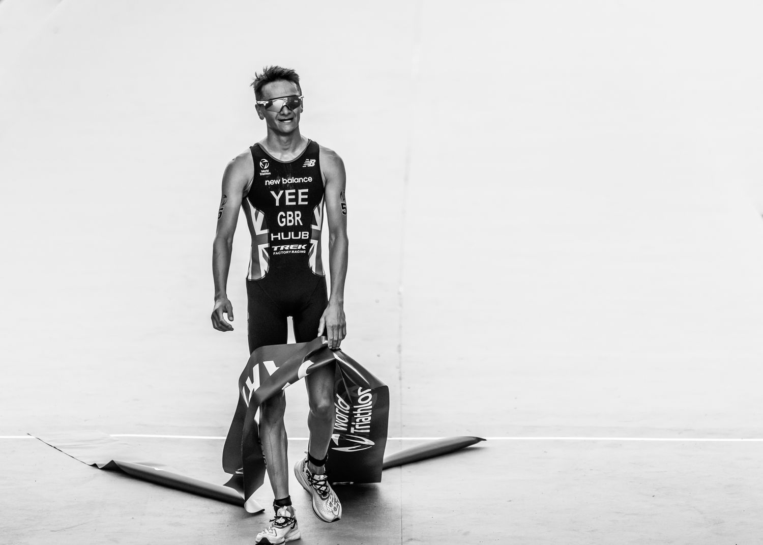 alex yee in black and white trisuits pose during a competitive event.