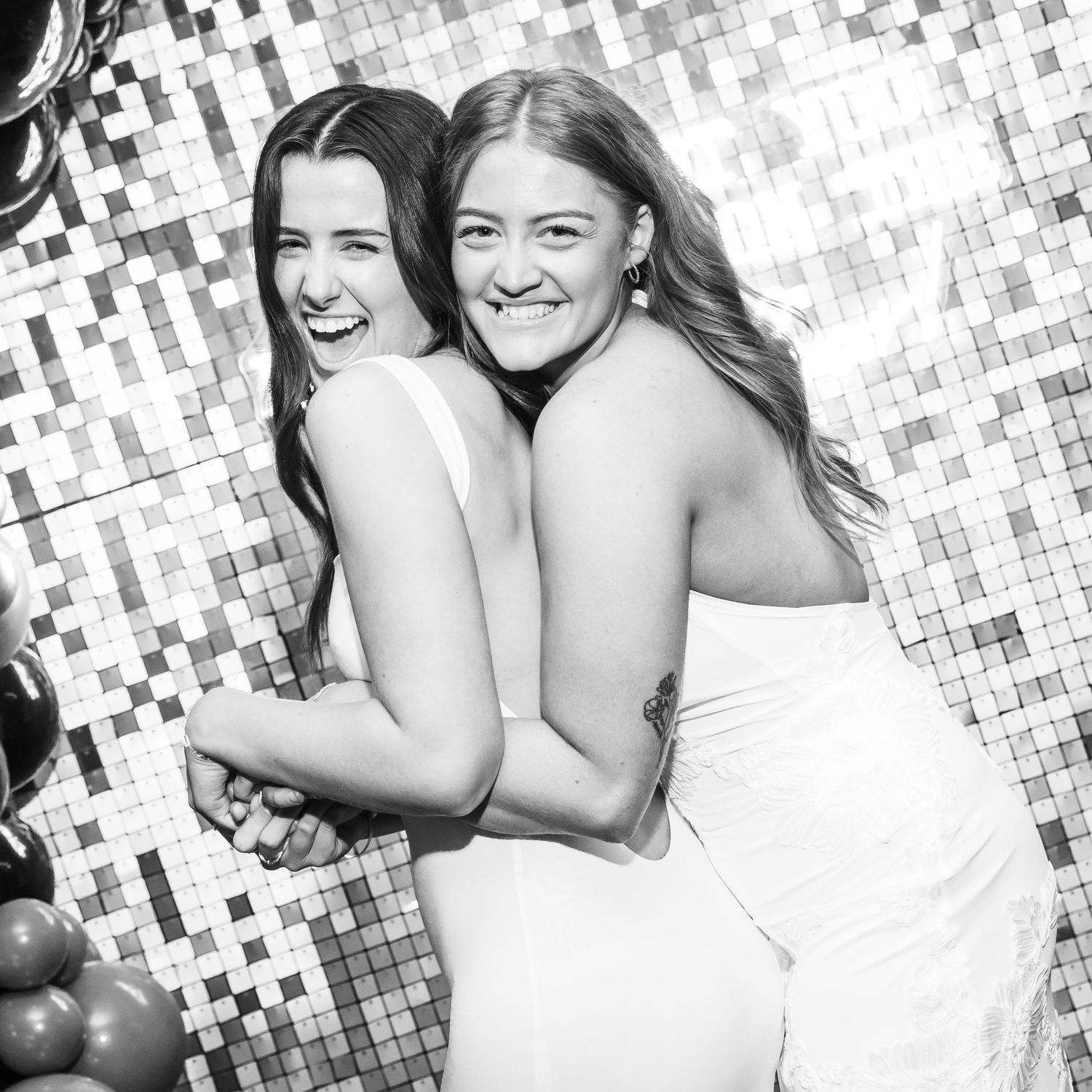 Black and white photo of two formal dresses against a sparkly backdrop.