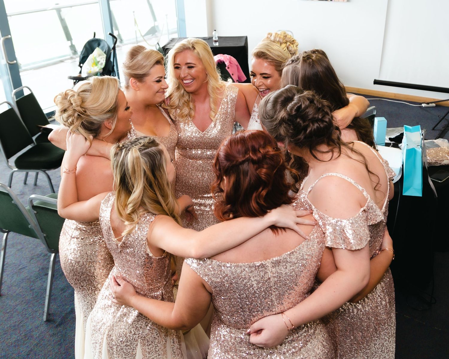 Bridesmaids in sparkly rose gold dresses sharing emotional moments together.