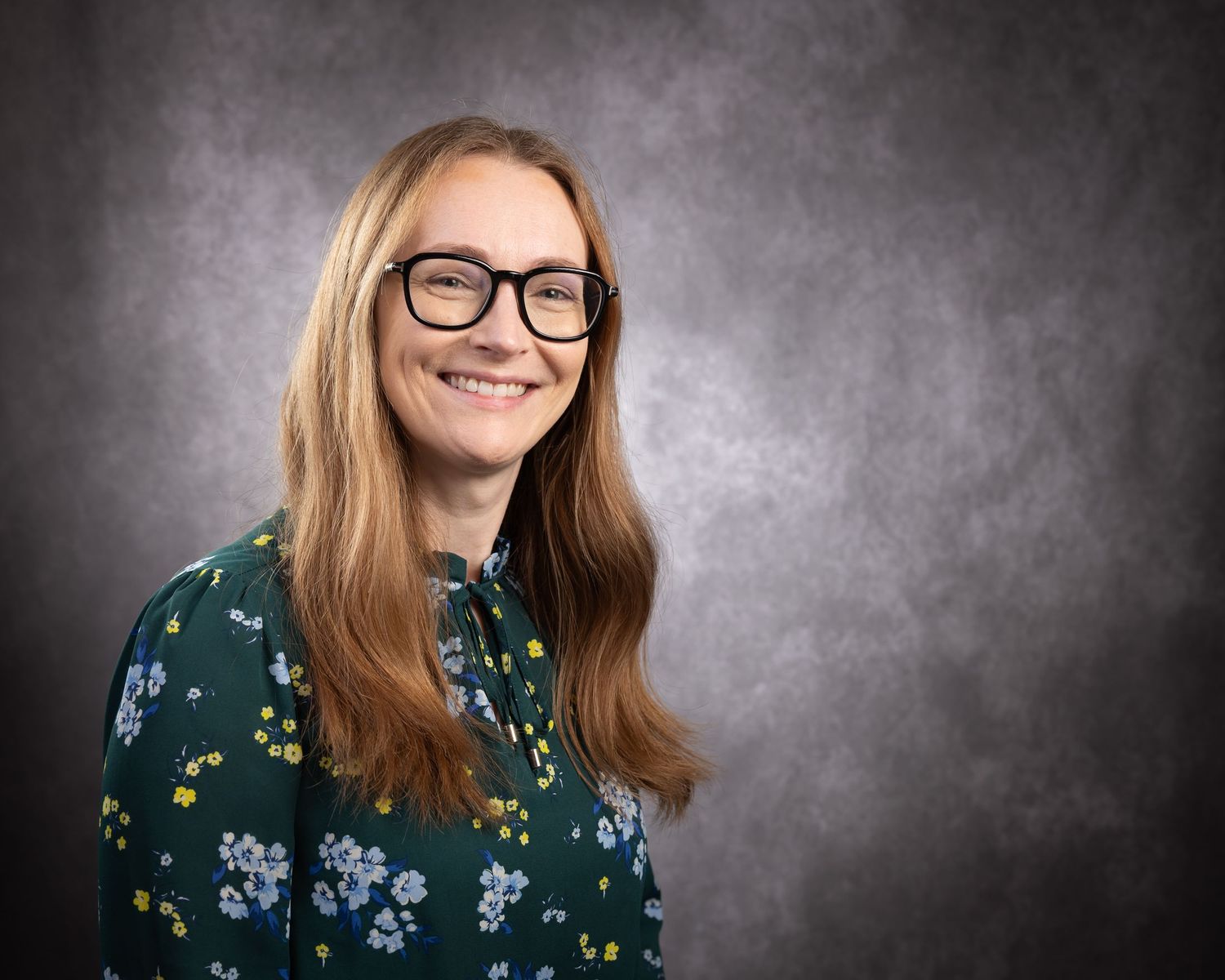 Professional headshot series showing different poses and expressions against a dark gray studio background.