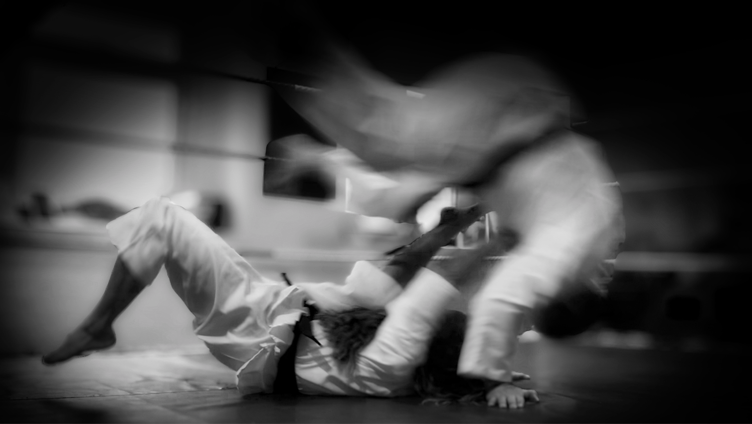 A grainy black and white photo captures intense martial arts ground combat.