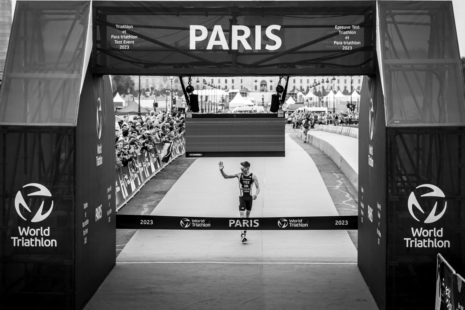 A triathlon competition venue in Paris with large event banners and branding.