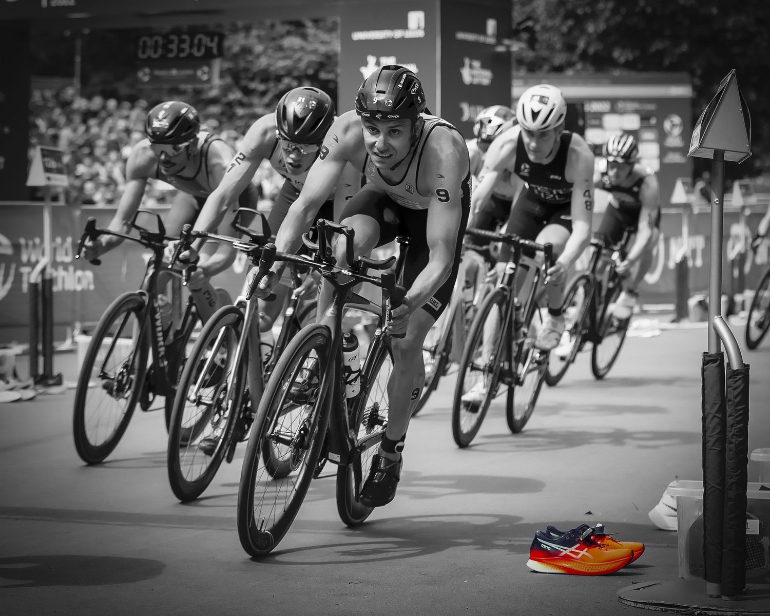 Black and white image of triathletes racing in tight formation on urban course in leeds