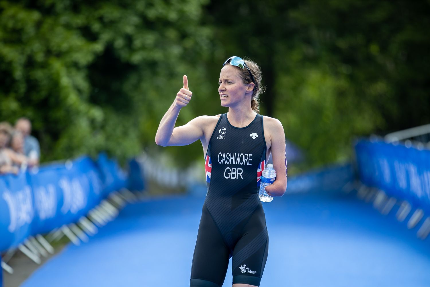 Athlete competing in triathlon race on blue running track.