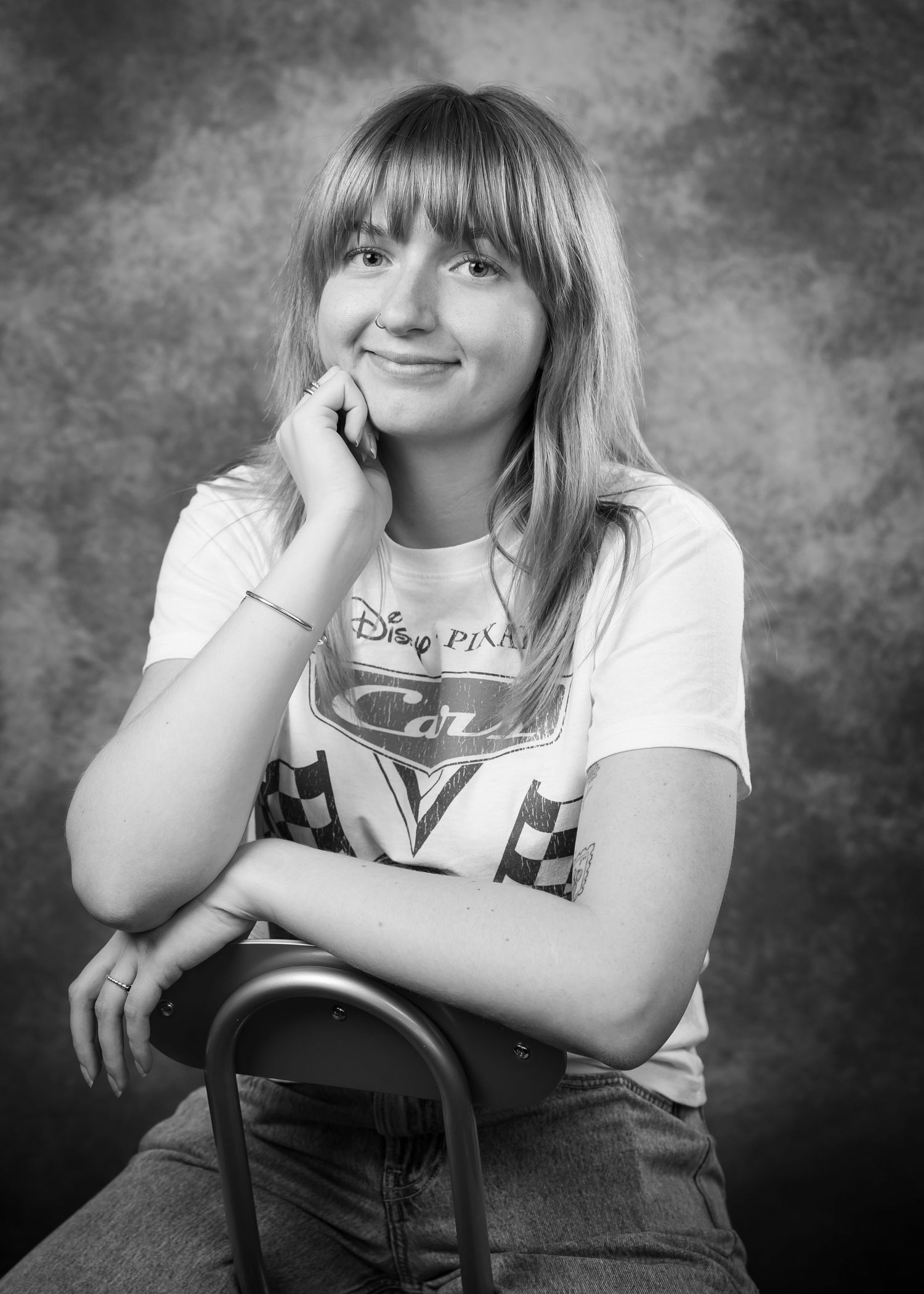 A series of four black and white studio portraits showing someone in a casual white t-shirt posing with relaxed expressions.