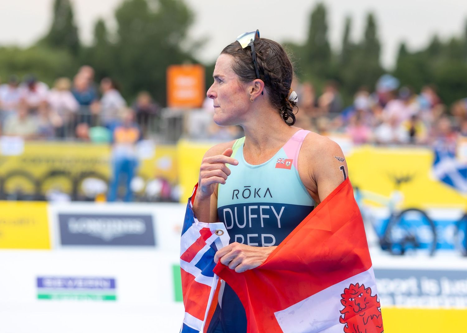 triAthlete with flag celebrating at outdoor sporting competition.