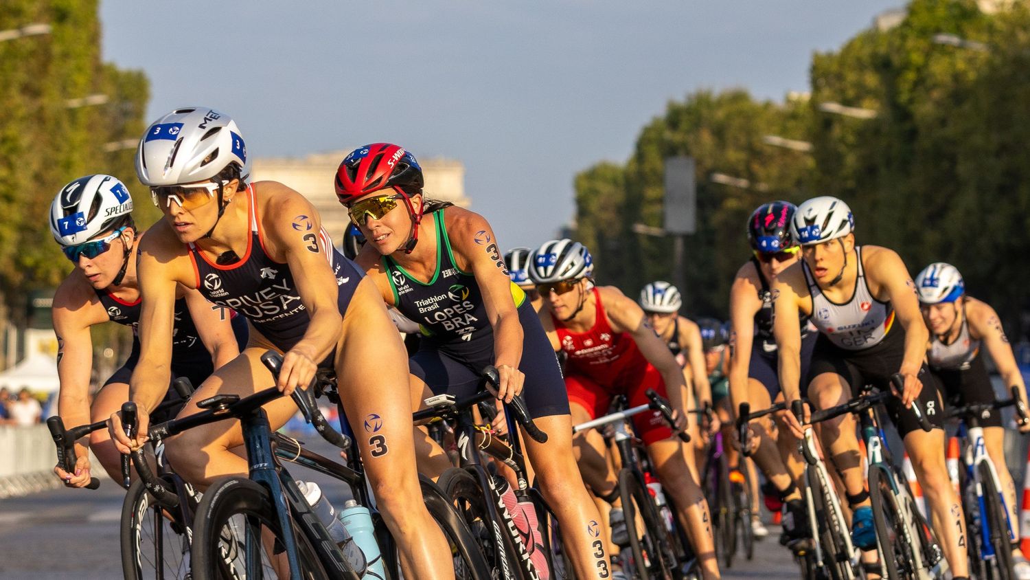 Group of triathletes racing in a competitive triathlon event on a sunny day. paris