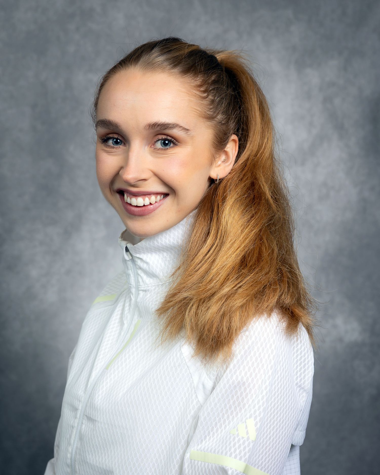 Person wearing a white turtleneck sweater poses against a gray background in a series of studio portraits.