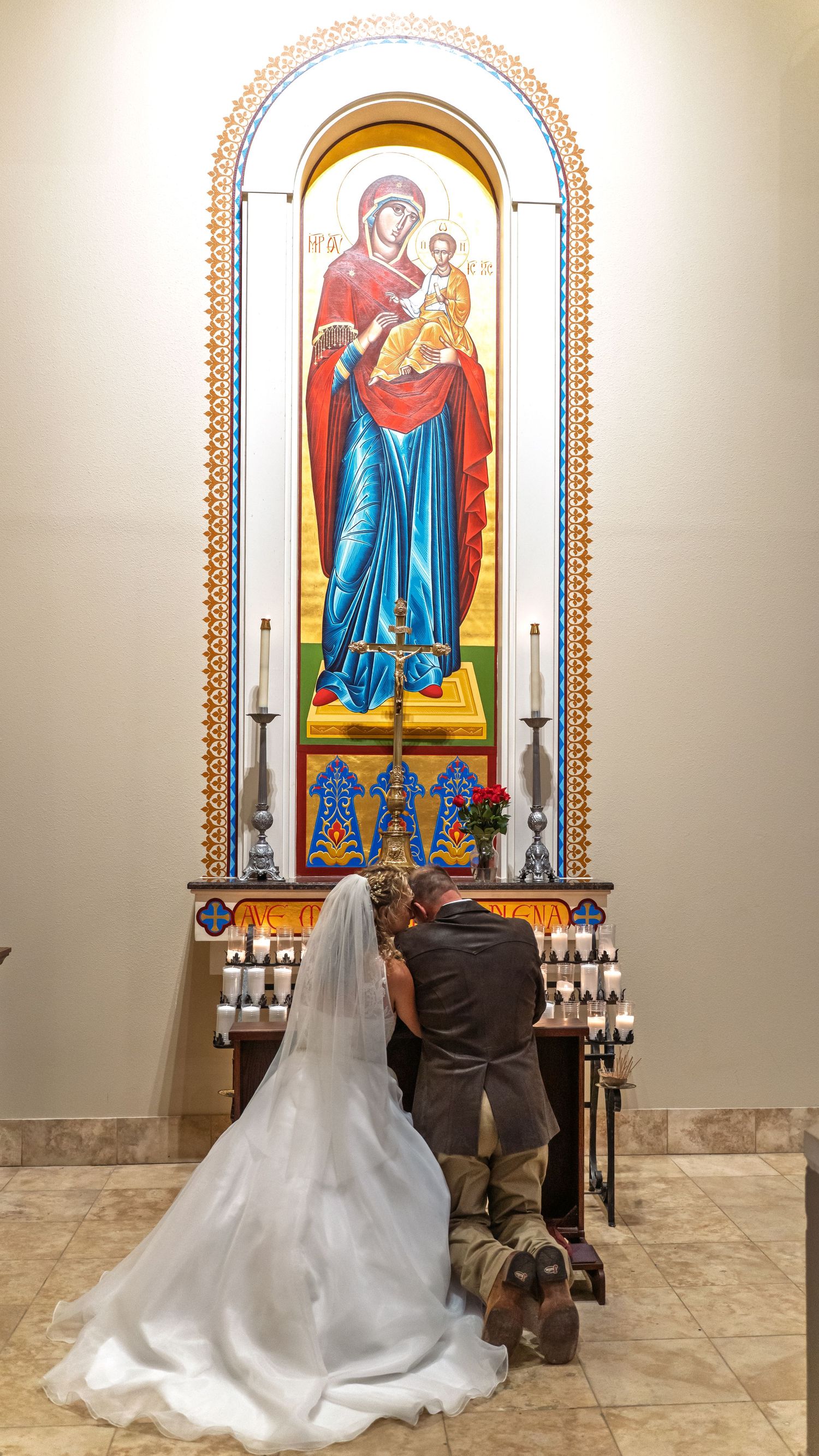 Bride and groom kneeling before Our Lady