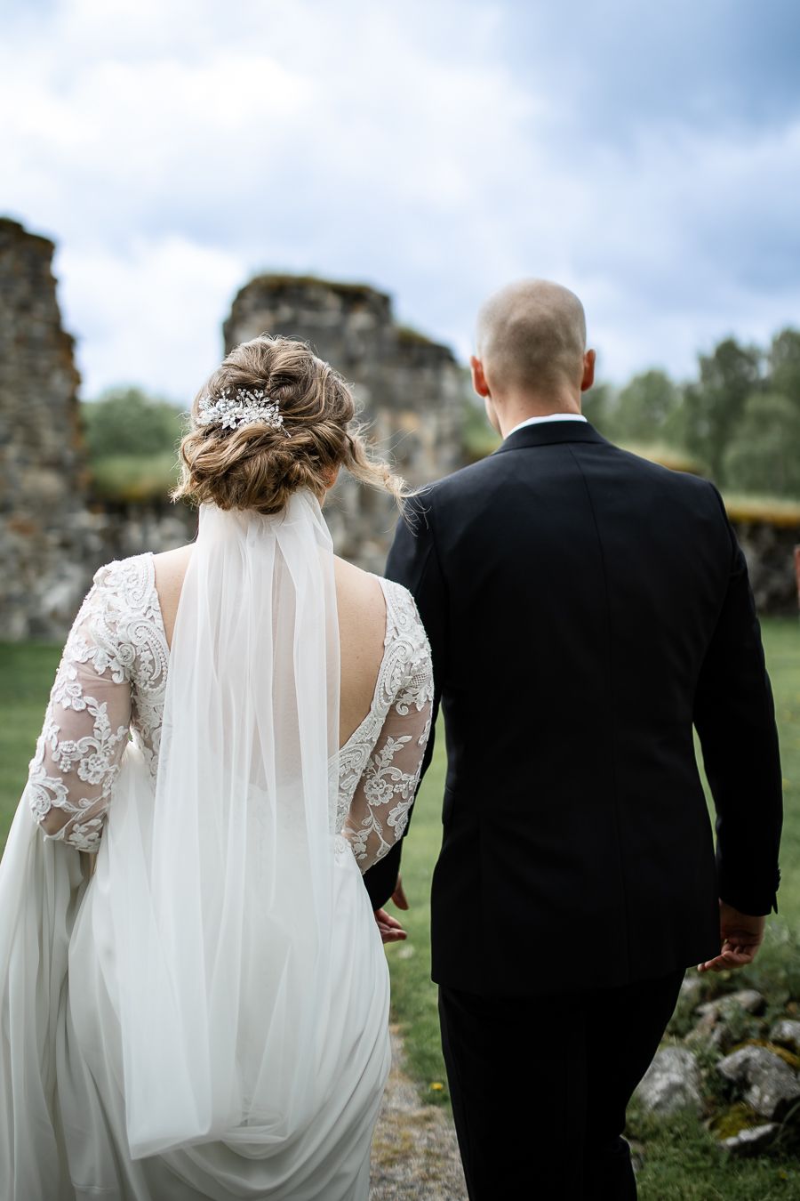 Bröllopsfotografering i Selånger, ett par går med ryggarna mot kameran