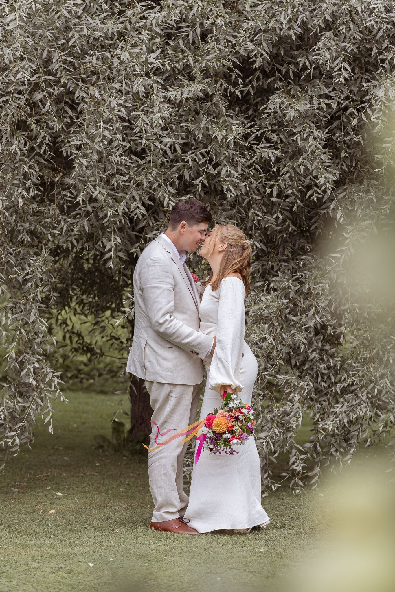 Porträttfotografering med brudpar i grön miljö