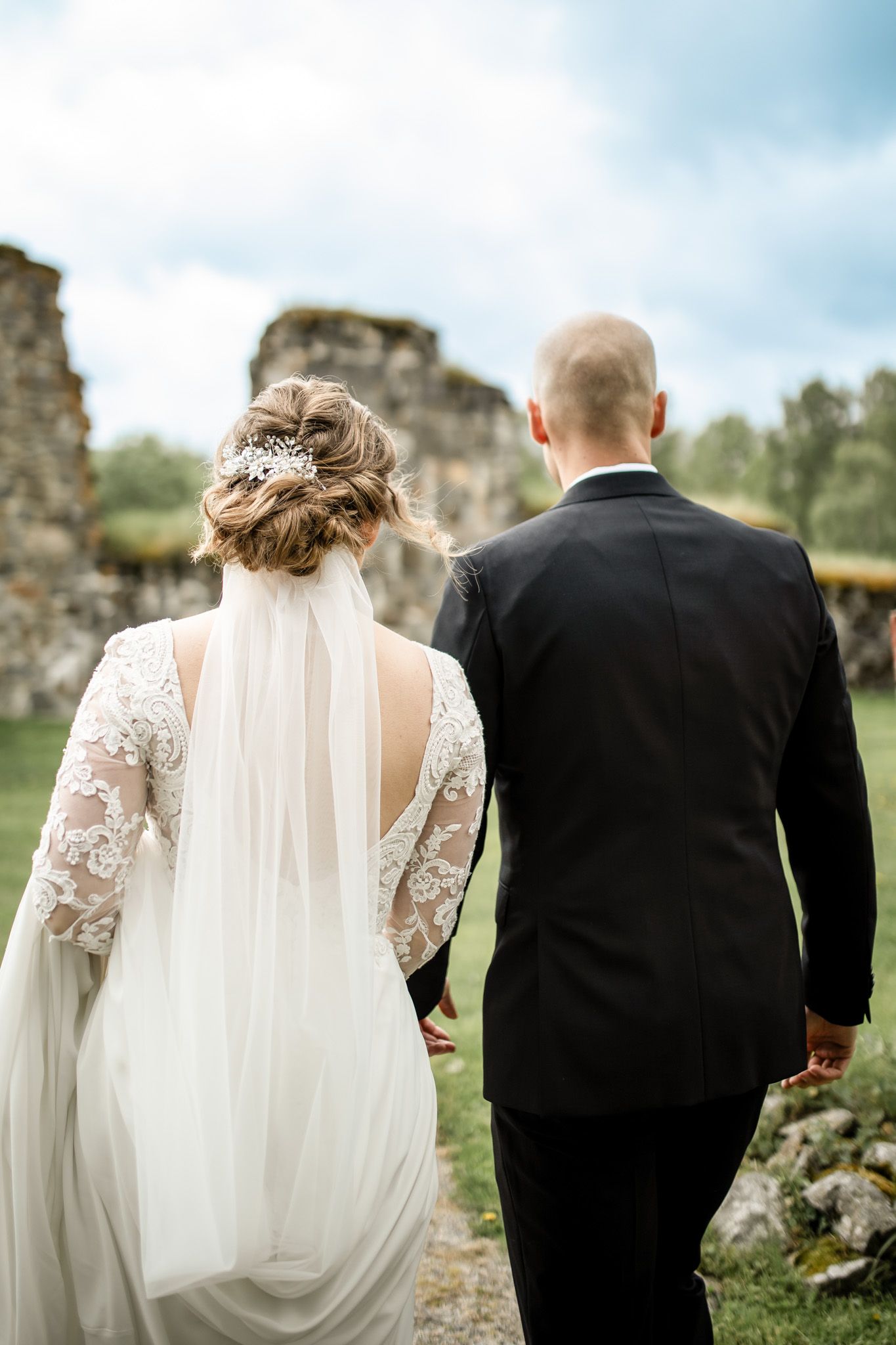Bröllopsfotografering, brudparet går med ryggarna mot kameran