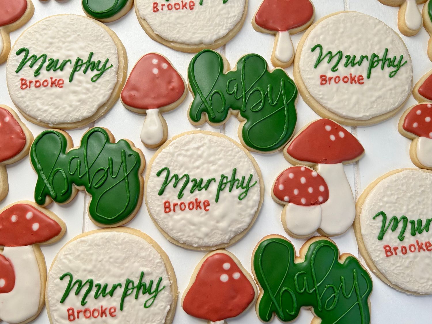 Woodland themed cookies with red mushrooms and green leaf designs.