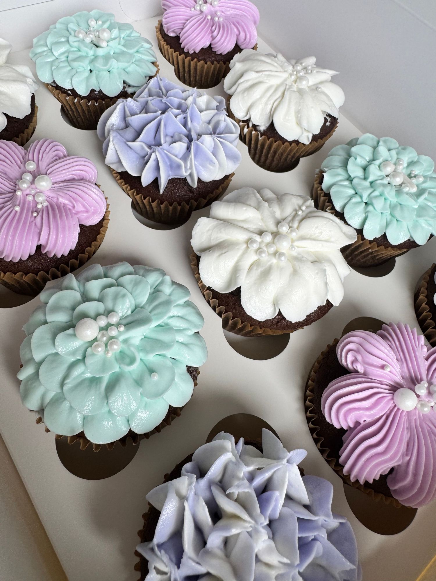 Pastel colored cupcakes with lavender, mint green and white swirled frosting decorations.