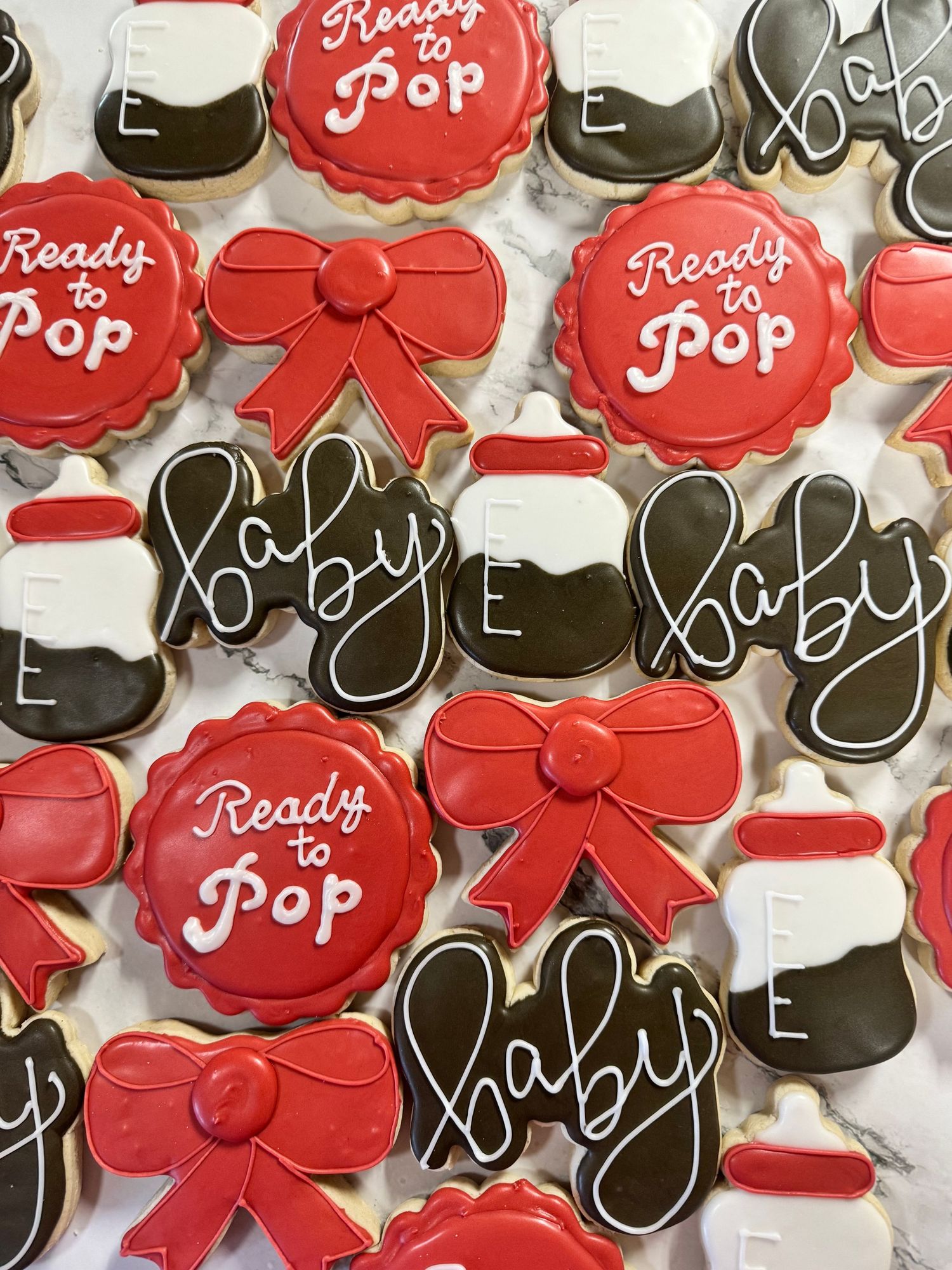 Decorated sugar cookies with red and black icing featuring Mickey Mouse designs, bows, and text details.
