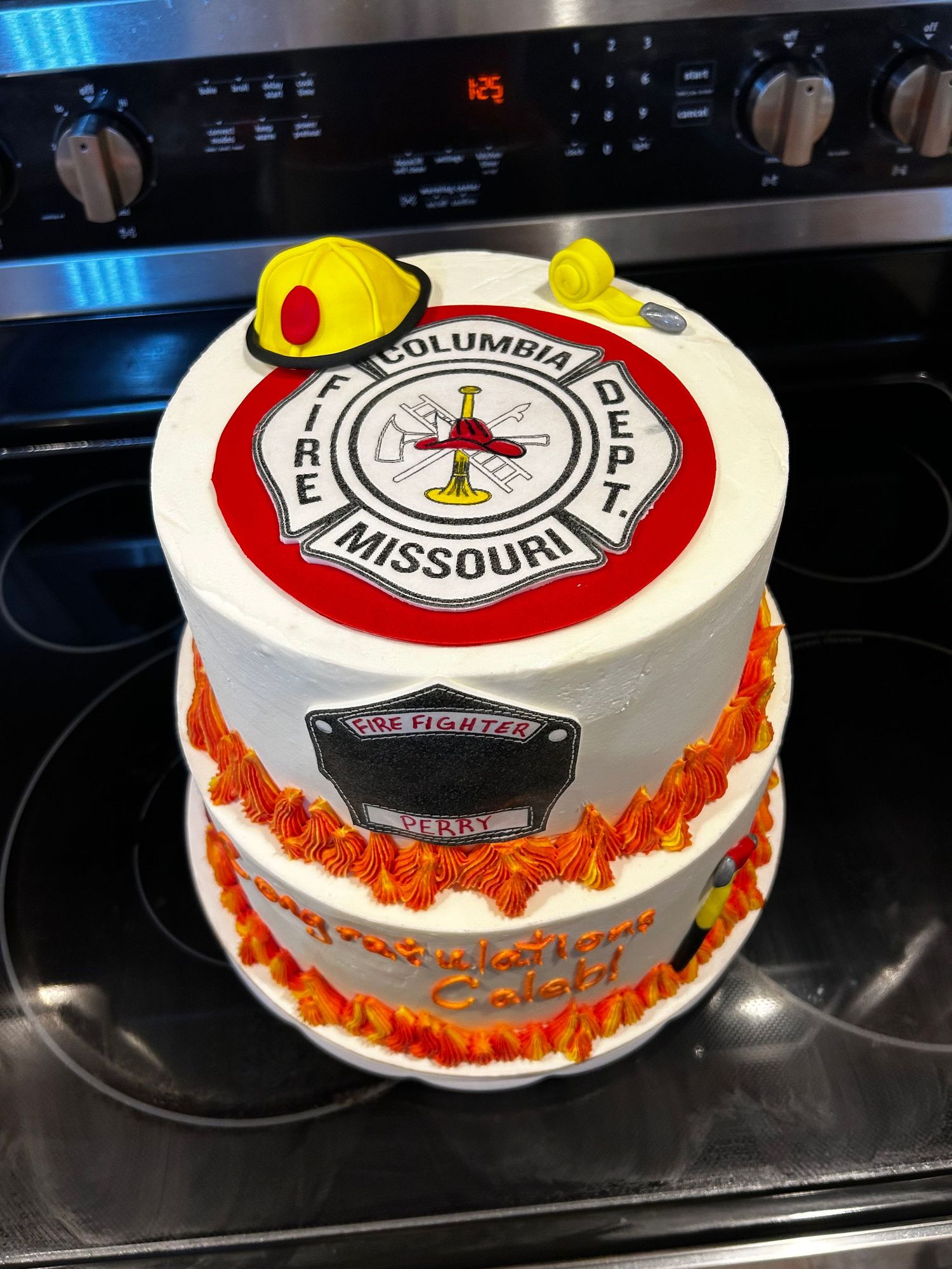 A round cake decorated with a Missouri fire department emblem and orange trim.
