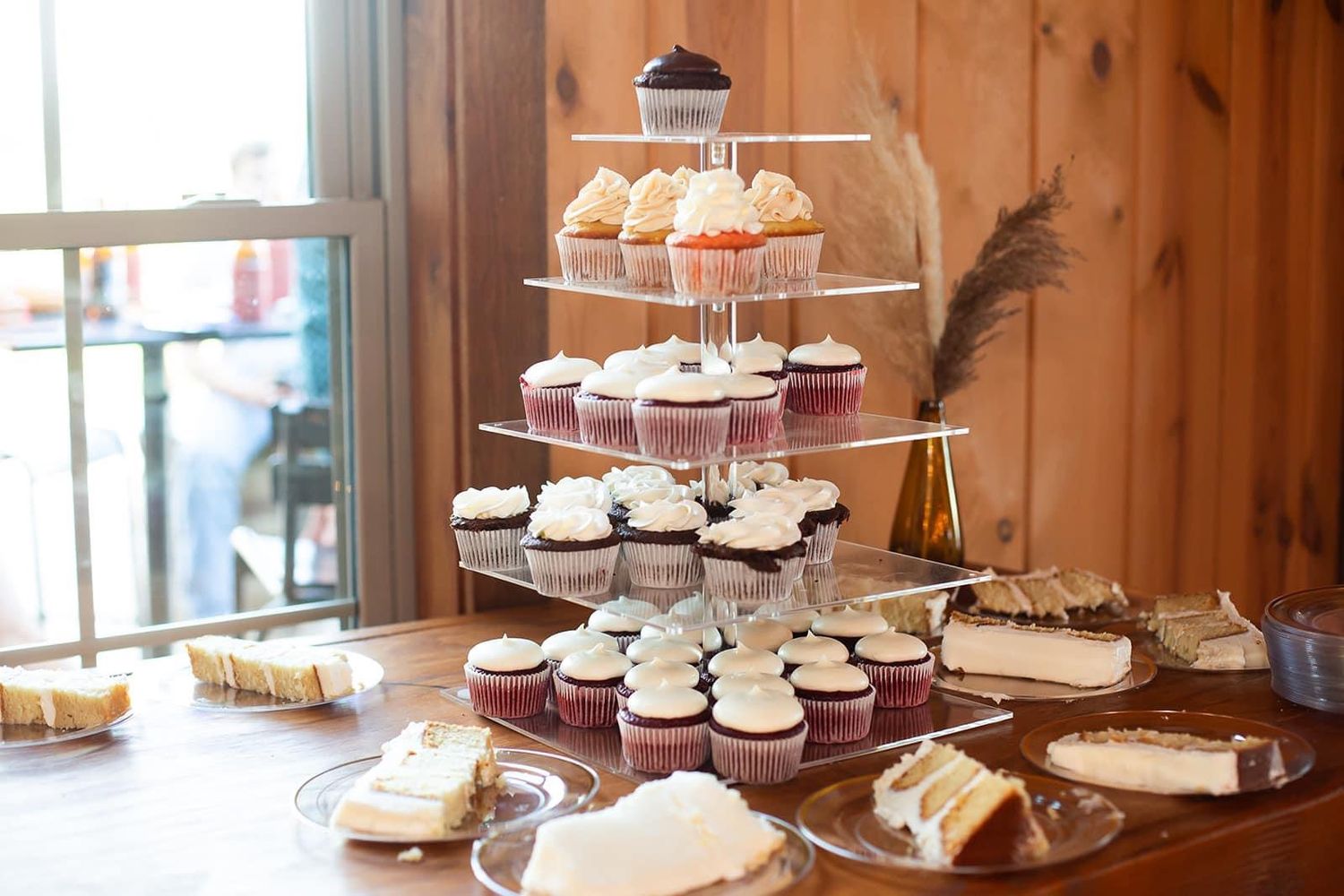 Multi-tiered dessert display with cupcakes and treats arranged on white cake stands.