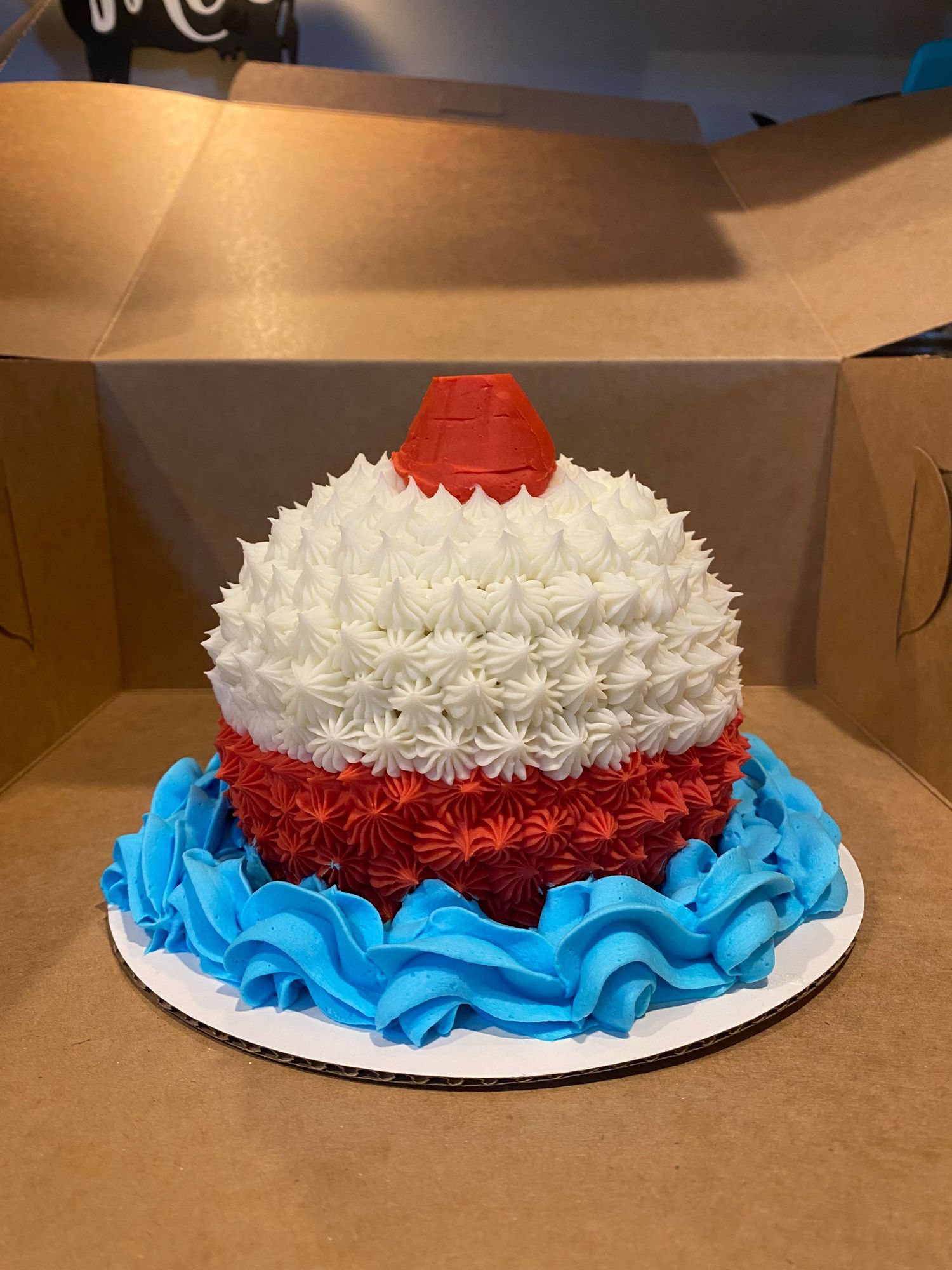 A patriotic themed cake with red, white, and blue ruffled frosting layers.