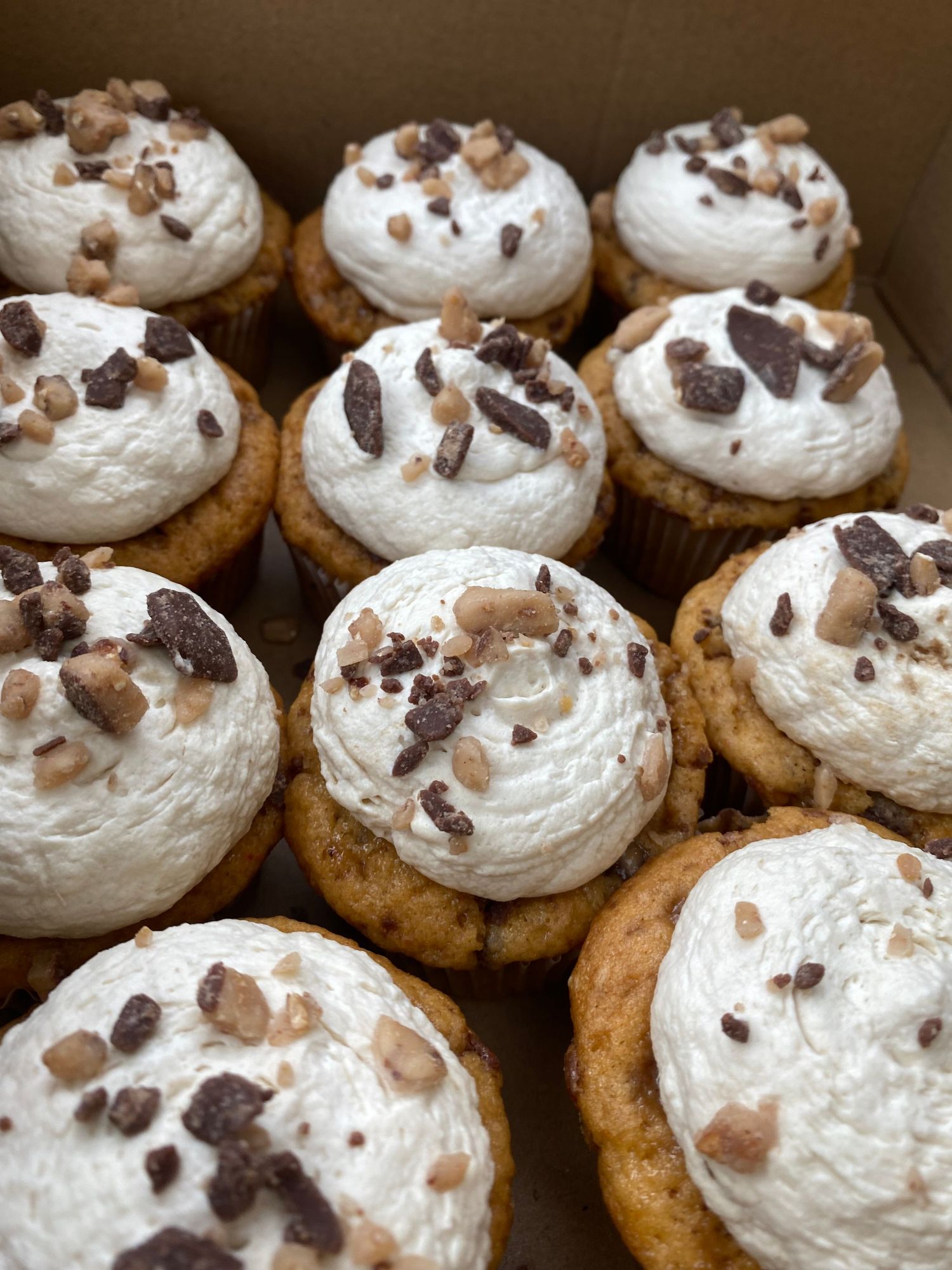Chocolate chip cookies topped with swirled white frosting and chocolate chips.