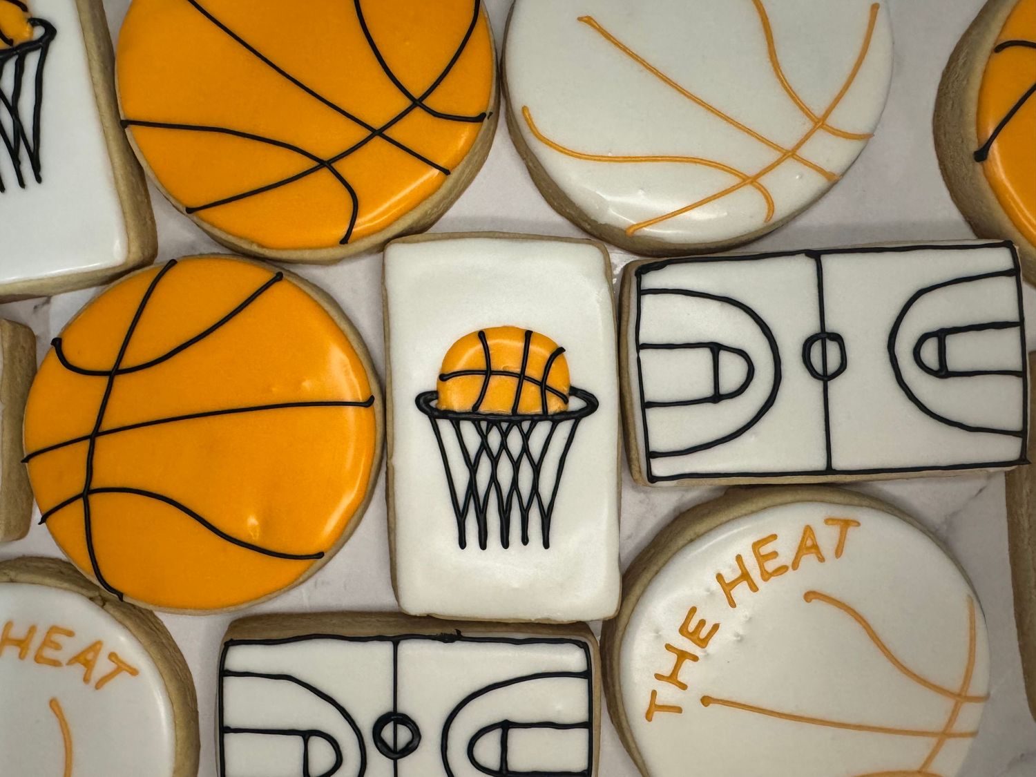 Basketball themed sugar cookies decorated with orange and white royal icing.