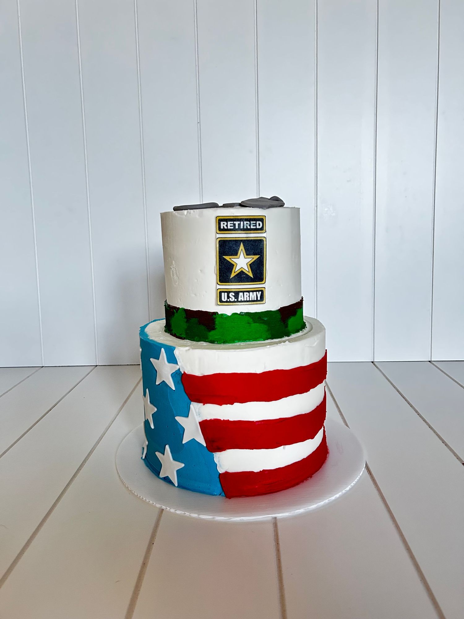 Patriotic cake featuring American flag design and military insignia on white background.