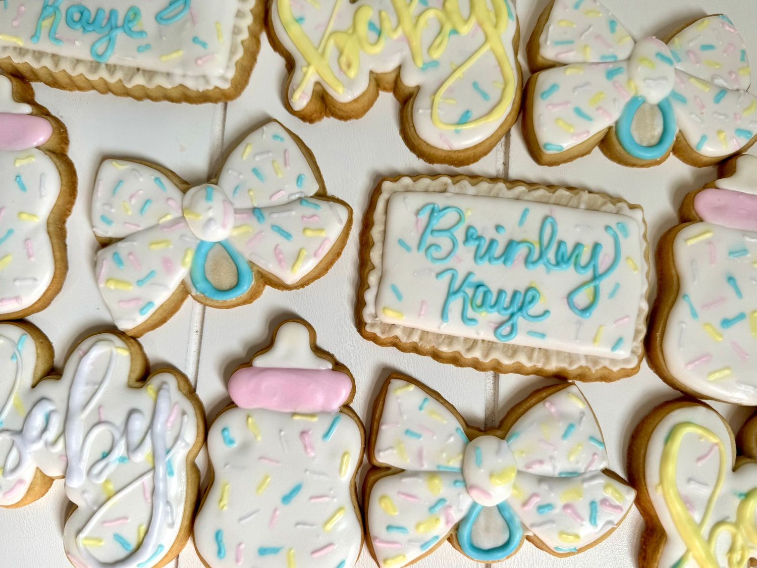 Baby shower cookies decorated with bows and pastel blue designs.