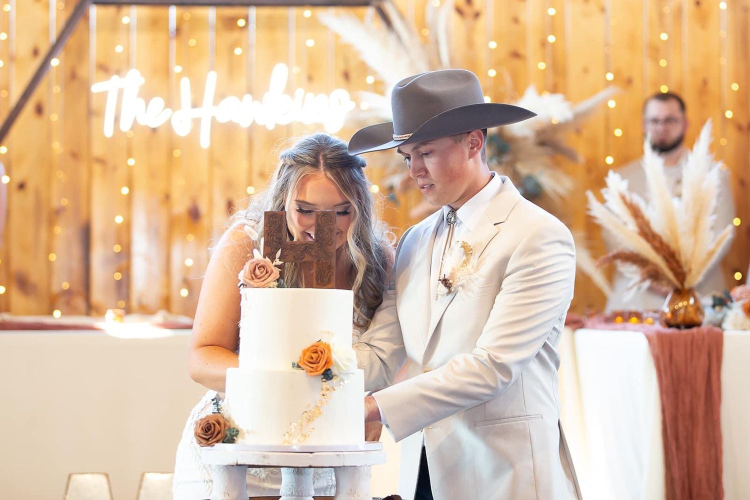 Rustic outdoor wedding reception setup with wooden tables and natural decor.
