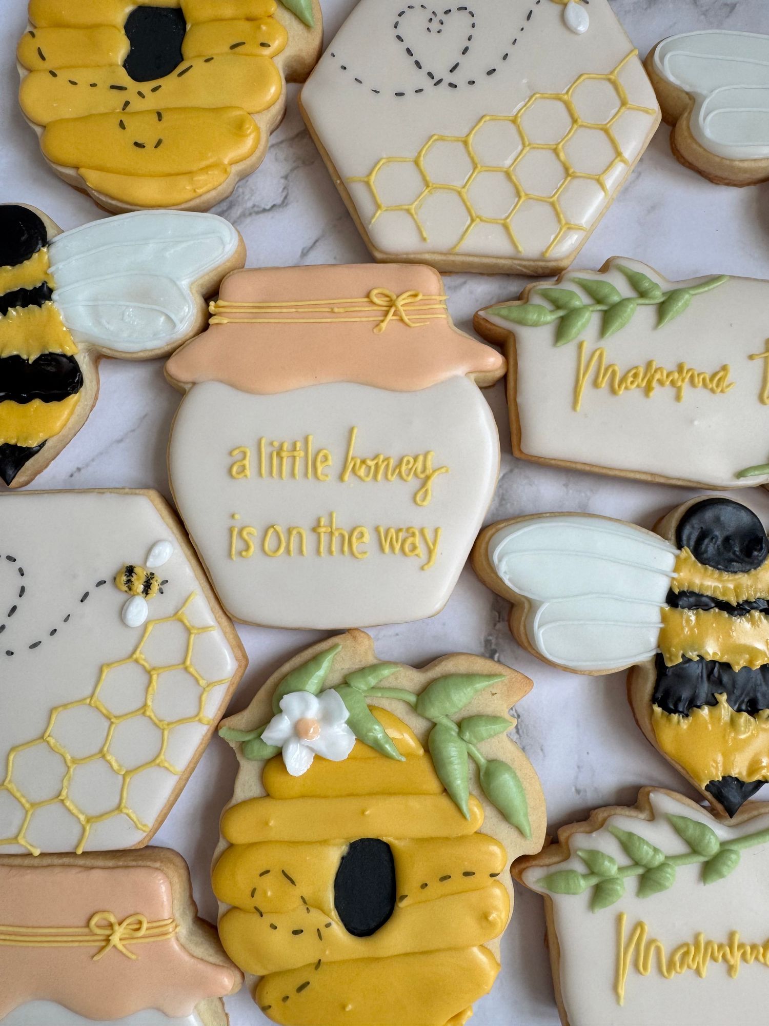 Honey-themed baby shower cookies with honeycomb patterns and bee designs in yellow and gold.