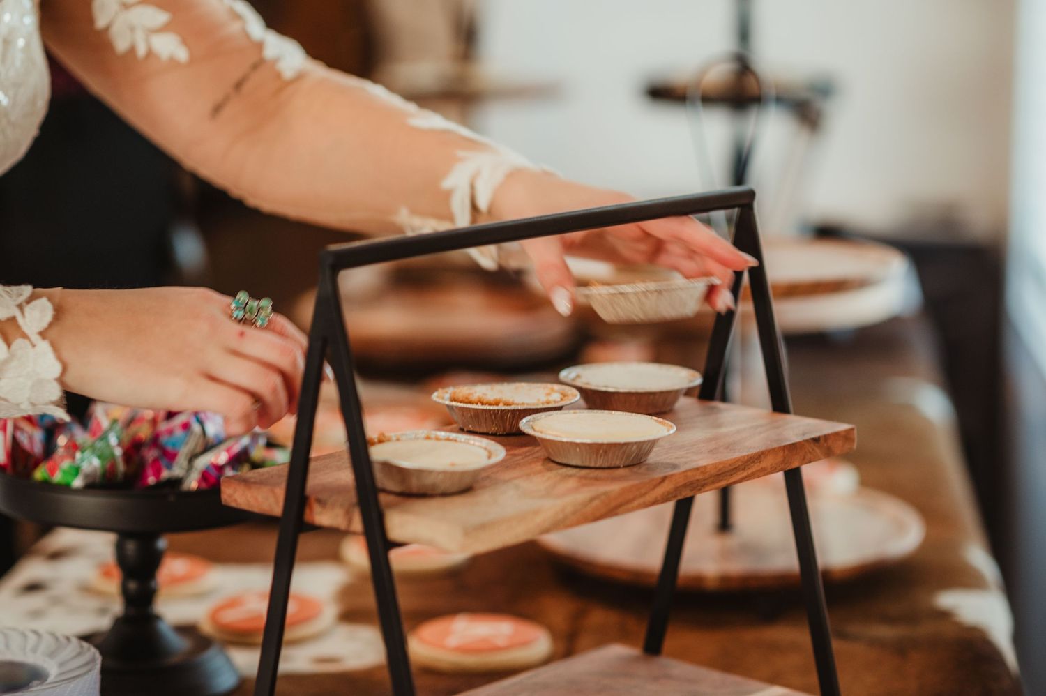 Wooden dessert display stands arranged on a rustic table.