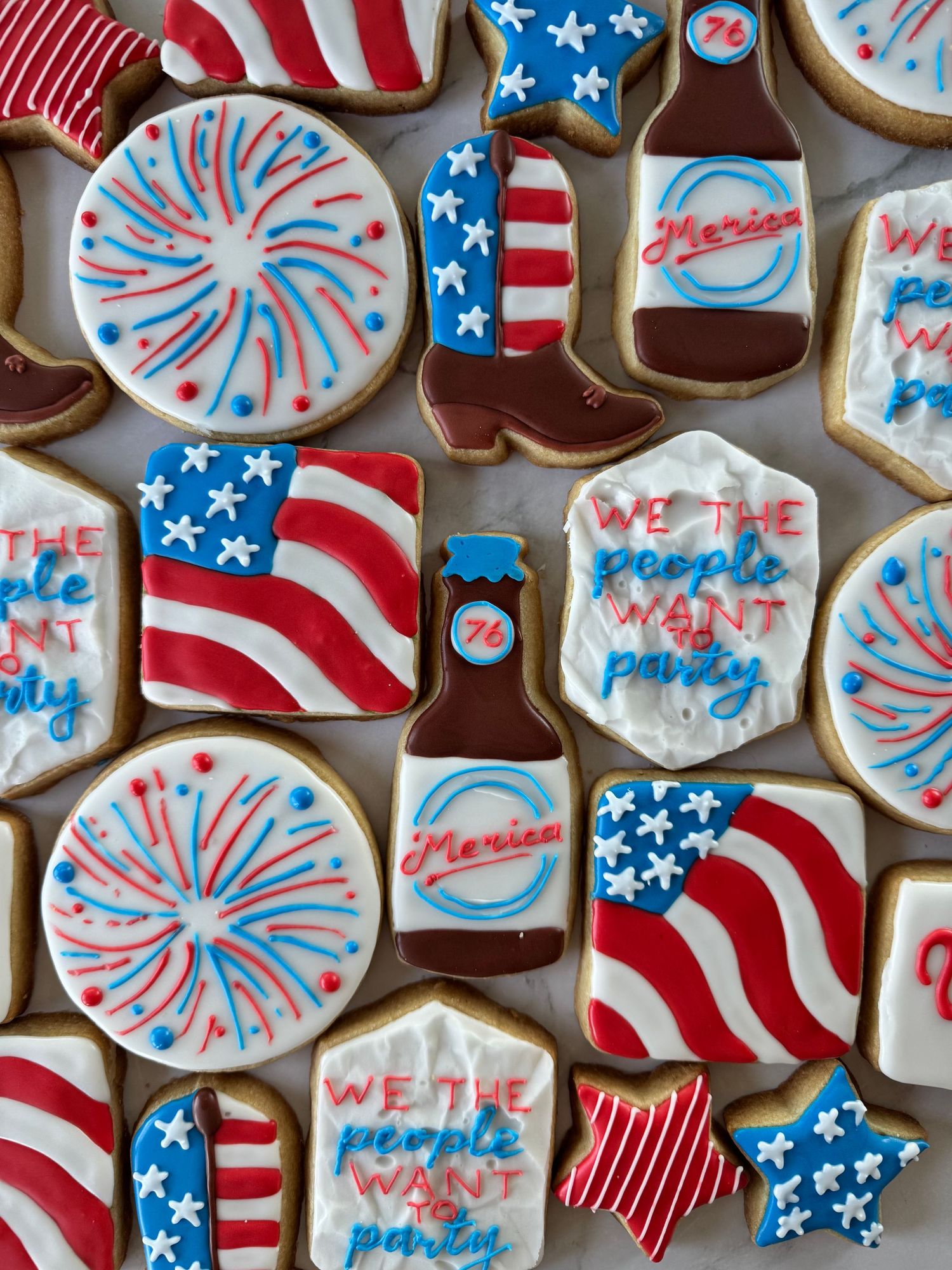 Patriotic sugar cookies decorated with American flag designs and firework patterns in red, white and blue.
