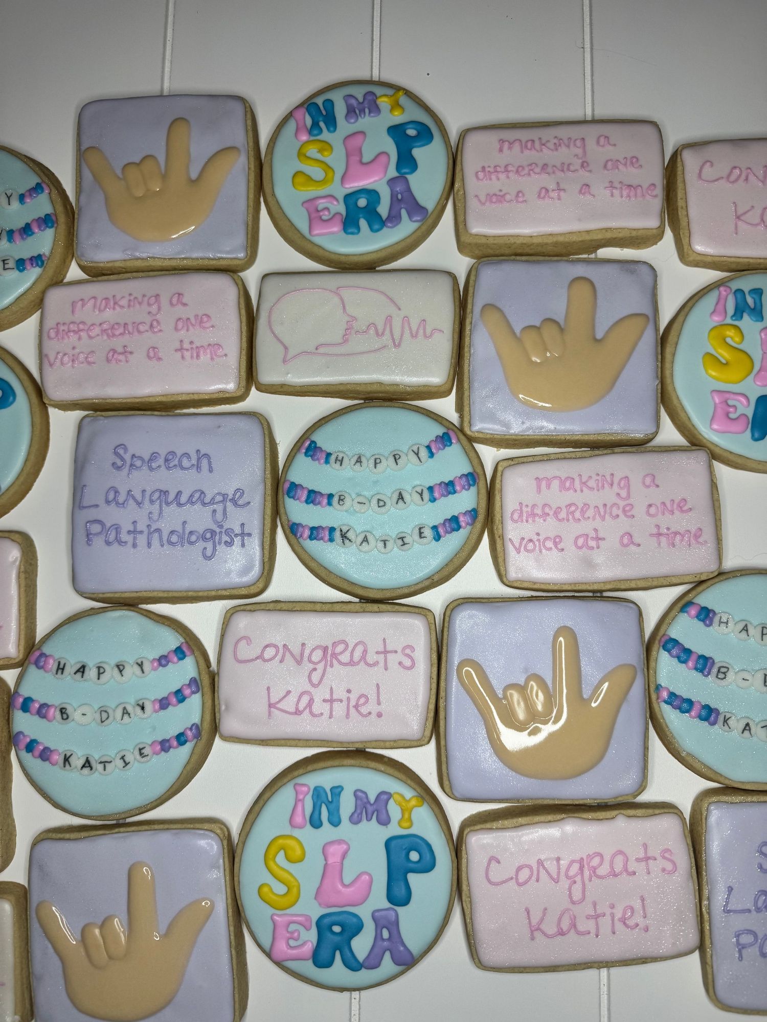 Graduation themed sugar cookies with congratulatory messages and academic symbols in pastel colors.